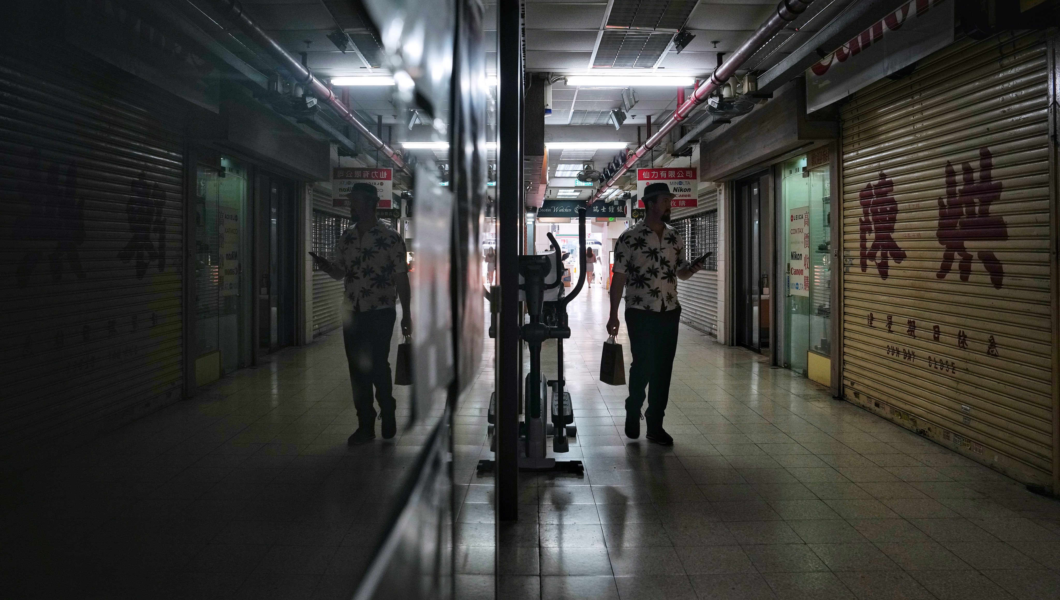 A shopper walks through Champagne Court in Tsim Sha Tsui on October 26. The 65-year-old shopping centre has been sold and earmarked for demolition, another example of Hong Kong retailers struggling to recover amid years of disruption and changing consumer patterns. Photo: Elson LI