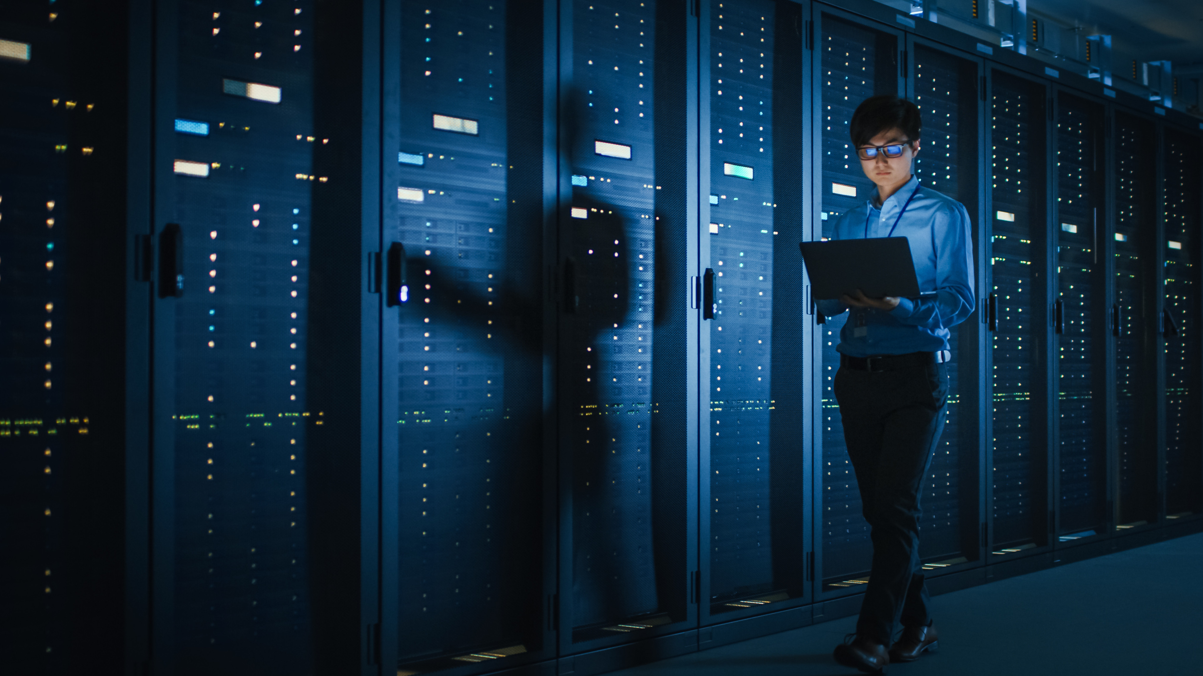 A technician inspects a row of server racks used for cloud computing. Photo: Shutterstock