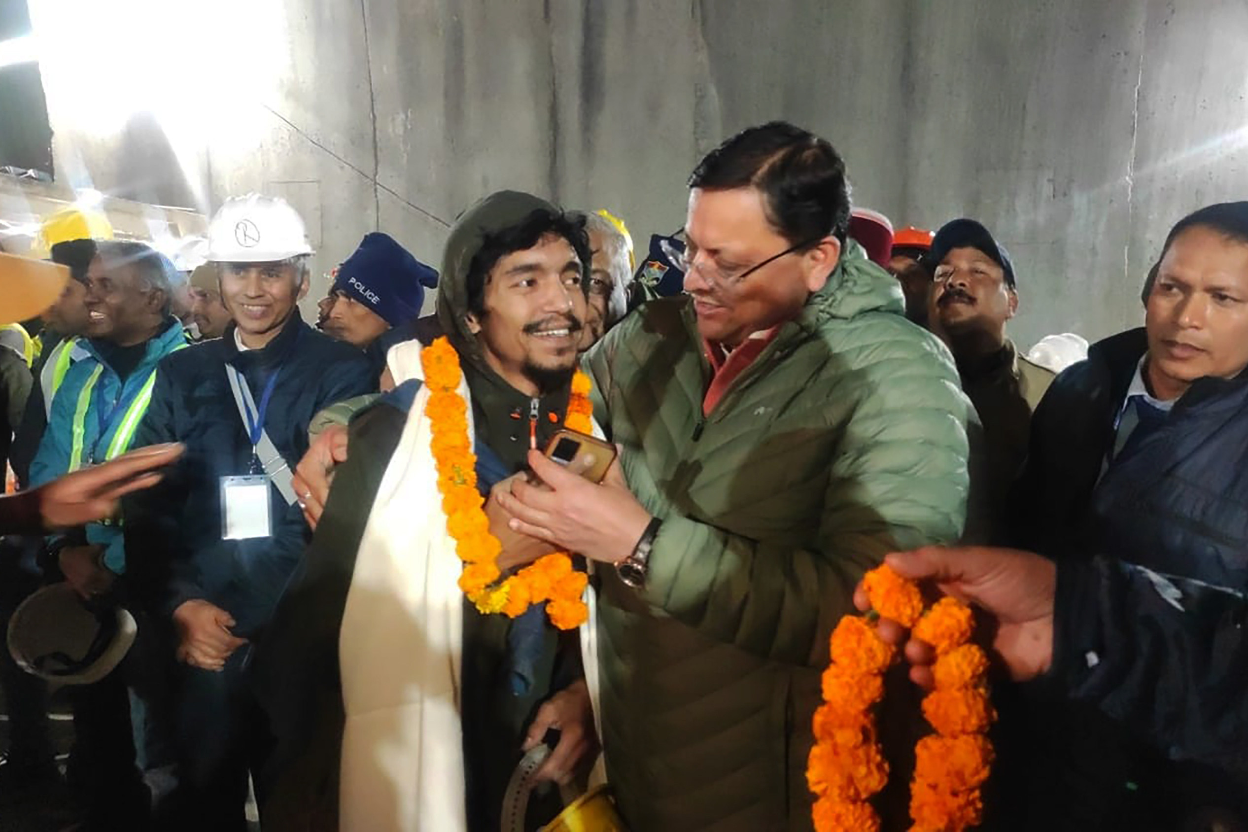 A rescued worker (centre left) is greeted after being pulled from the site of an under-construction road tunnel that collapsed. Photo: Uttarakhand State Department of Information and Public Relations via AP
