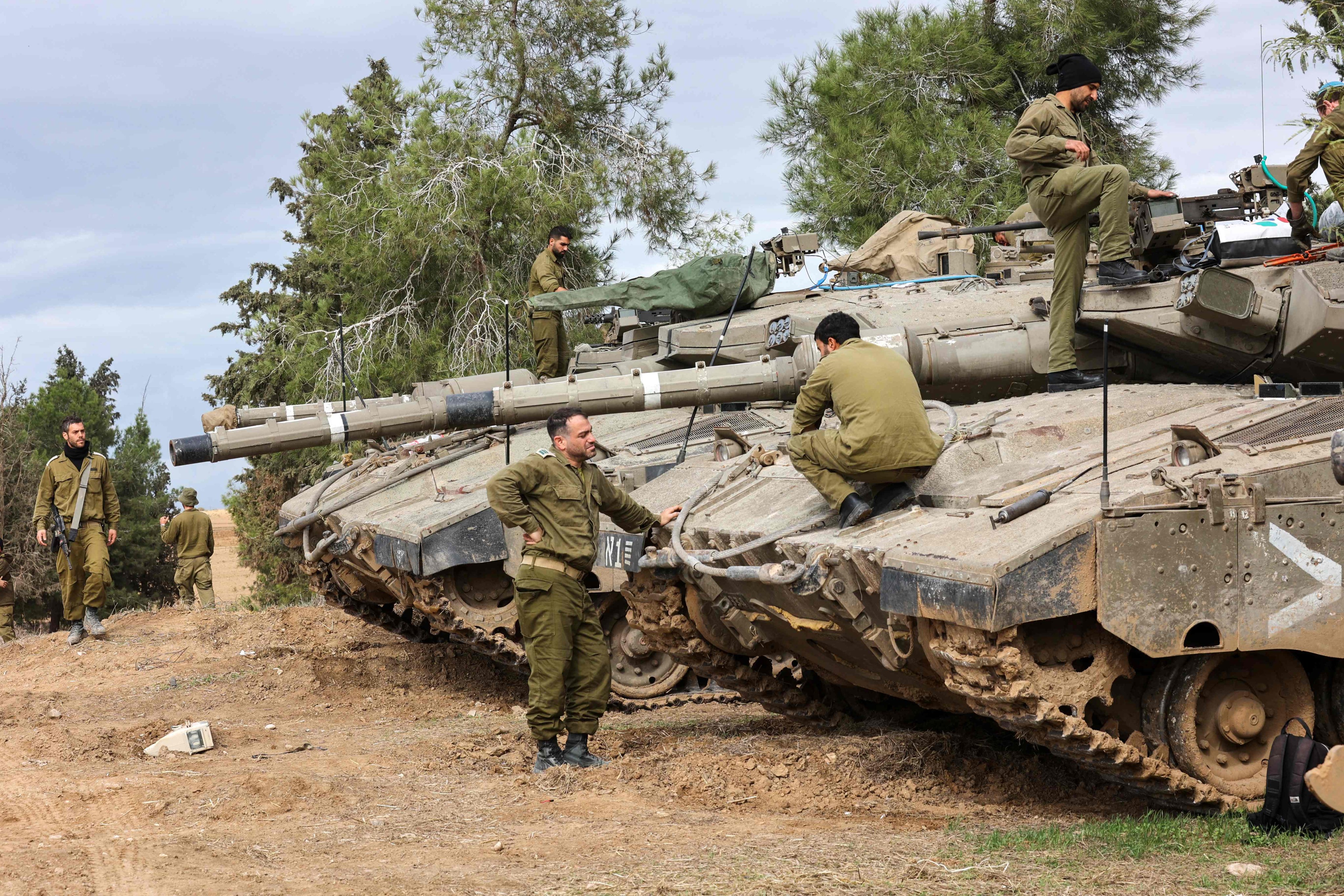Israeli soldiers carry out maintenance on tanks deployed on the southern border with the Gaza Strip on November 28, 2023, as a truce between Israel and Hamas entered a fifth day. Photo: AFP