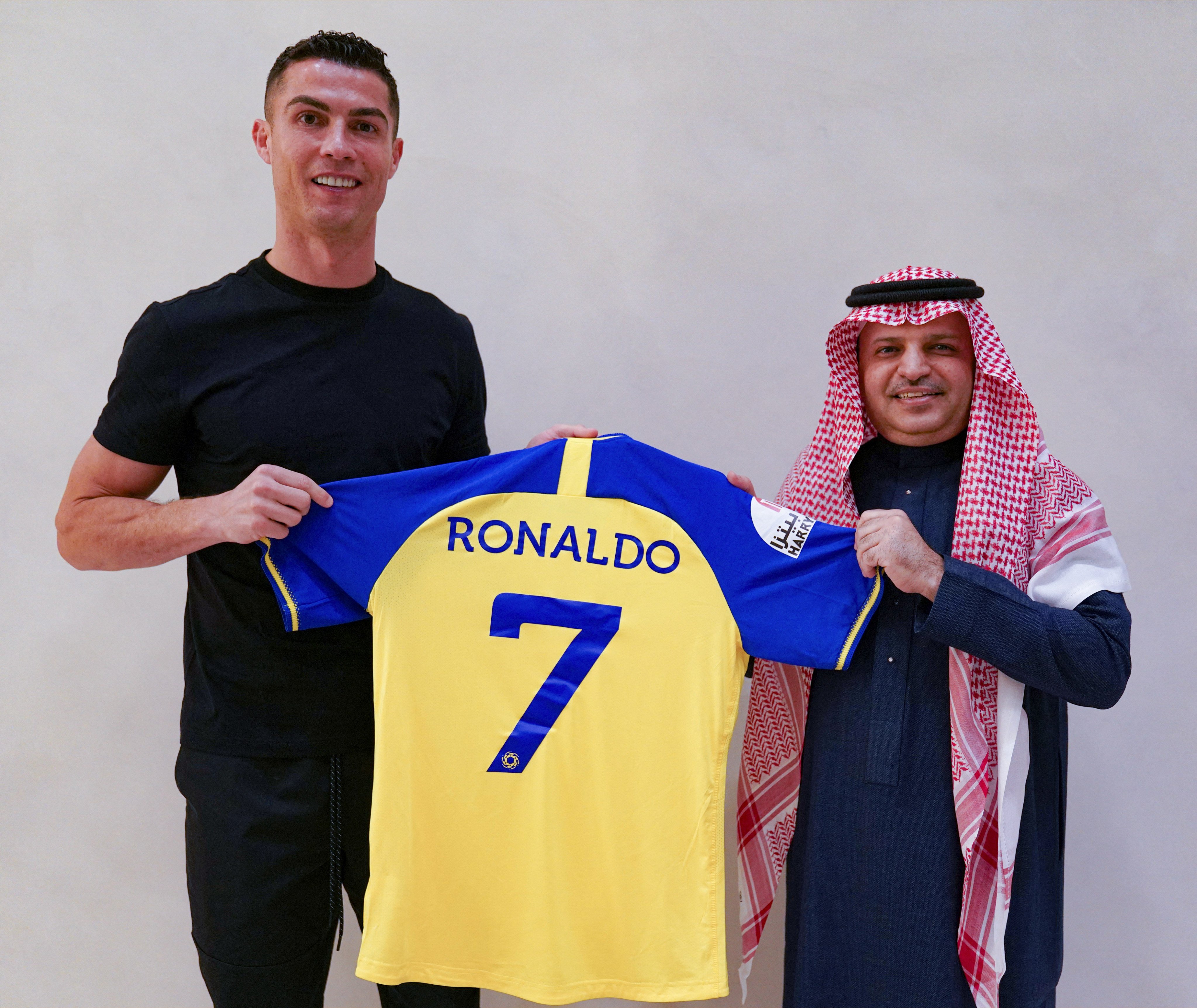 A handout picture released by Saudi Arabia’s al-Nassr football club shows Portugal’s forward Cristiano Ronaldo being presented with the club’s number seven jersey by club president Musalli Al-Muammar in Madrid on December 30, 2022 upon signing for the Saudi Arabian club. Cristiano Ronaldo on December 30 signed for al-Nassr of Saudi Arabia, the club announced, in a deal believed to be worth more than 200 million euros. The 37-year-old penned a contract which will take him to June 2025. (Photo by Al Nassr Football Club / AFP) / == RESTRICTED TO EDITORIAL USE - MANDATORY CREDIT “AFP PHOTO / HO /AL NASSR FOOTBALL CLUB” - NO MARKETING NO ADVERTISING CAMPAIGNS - DISTRIBUTED AS A SERVICE TO CLIENTS == PHOTO: AFP