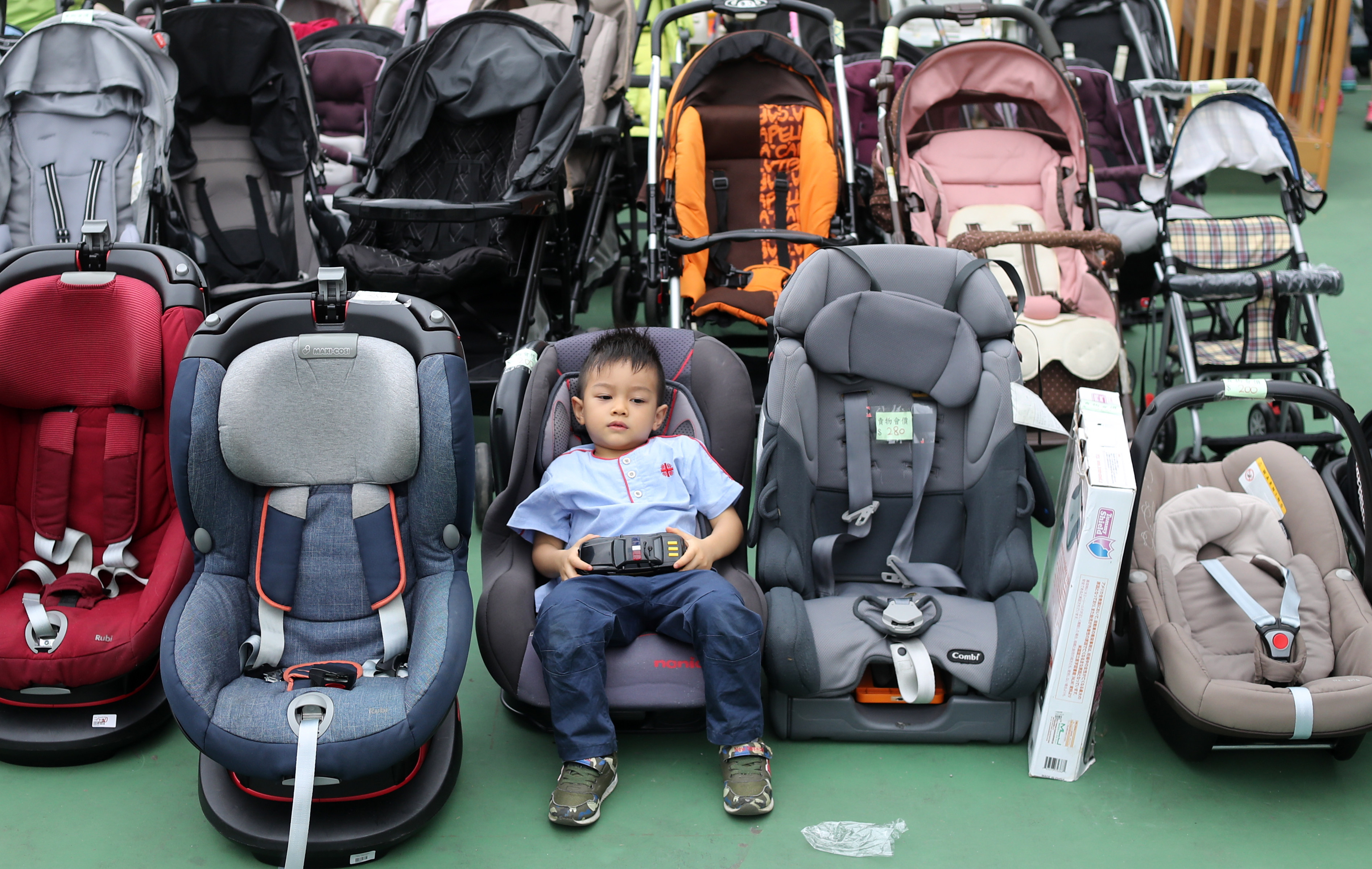A child sits in a baby seat at a charity bazaar at Hong Kong’s Victoria Park in November 2018. Under current legislation, children under three years old and sitting in the front seat must use child safety seats, while children sitting at the back and children above three years old are not required to do so. Photo: Winson Wong