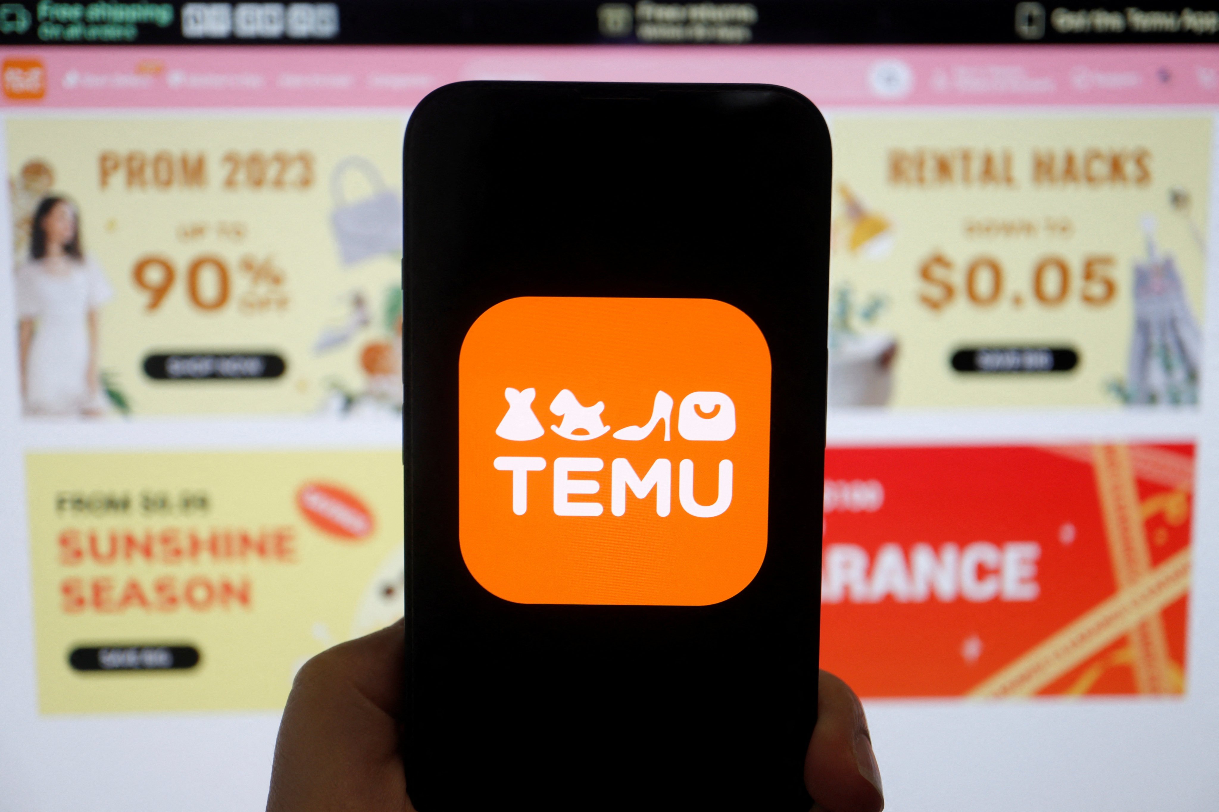 The logo of Temu is seen on a mobile phone displayed in front of its website, in this illustration picture taken April 26, 2023. Photo: Reuters