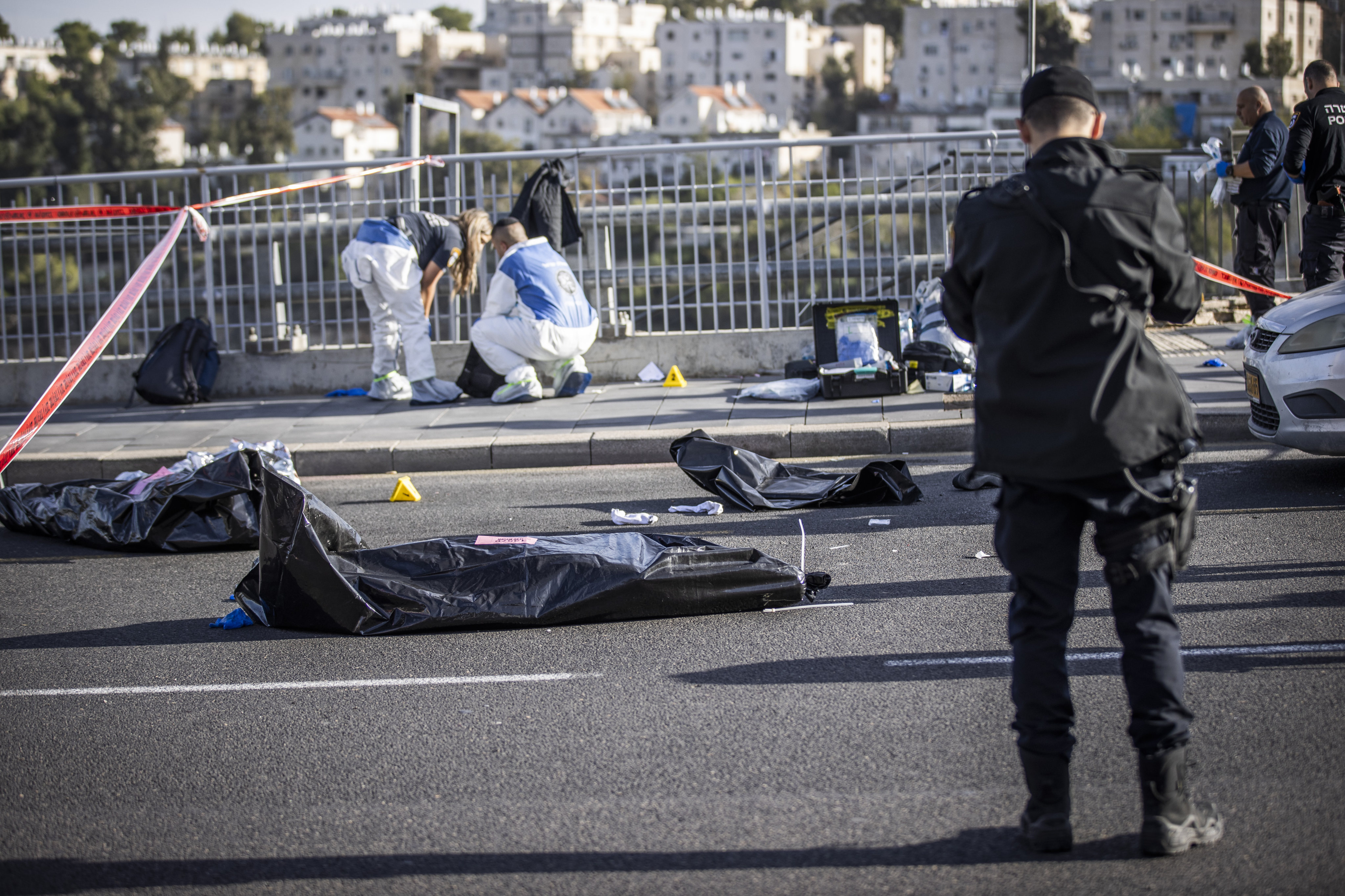 Officials work at the scene of a shooting attack involving two Palestinian attackers who opened fire on people waiting at a bus stop in Jerusalem, killing three people and injuring at least 16 others. Photo: dpa
