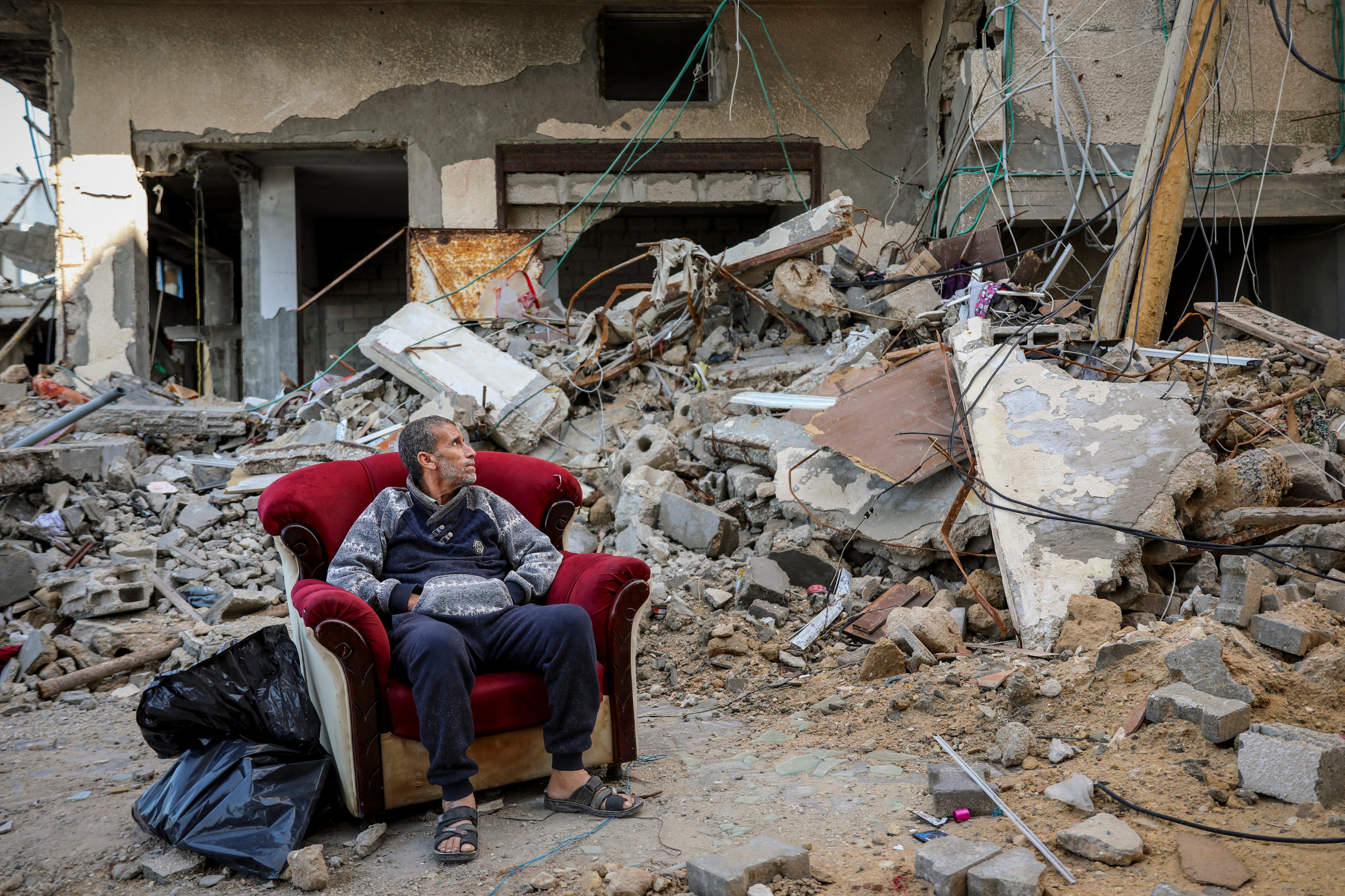 A Palestinian man sits in an armchair outside a destroyed building in Gaza City on Wednesday, the sixth day of the temporary truce between Hamas and Israel. Photo: AP