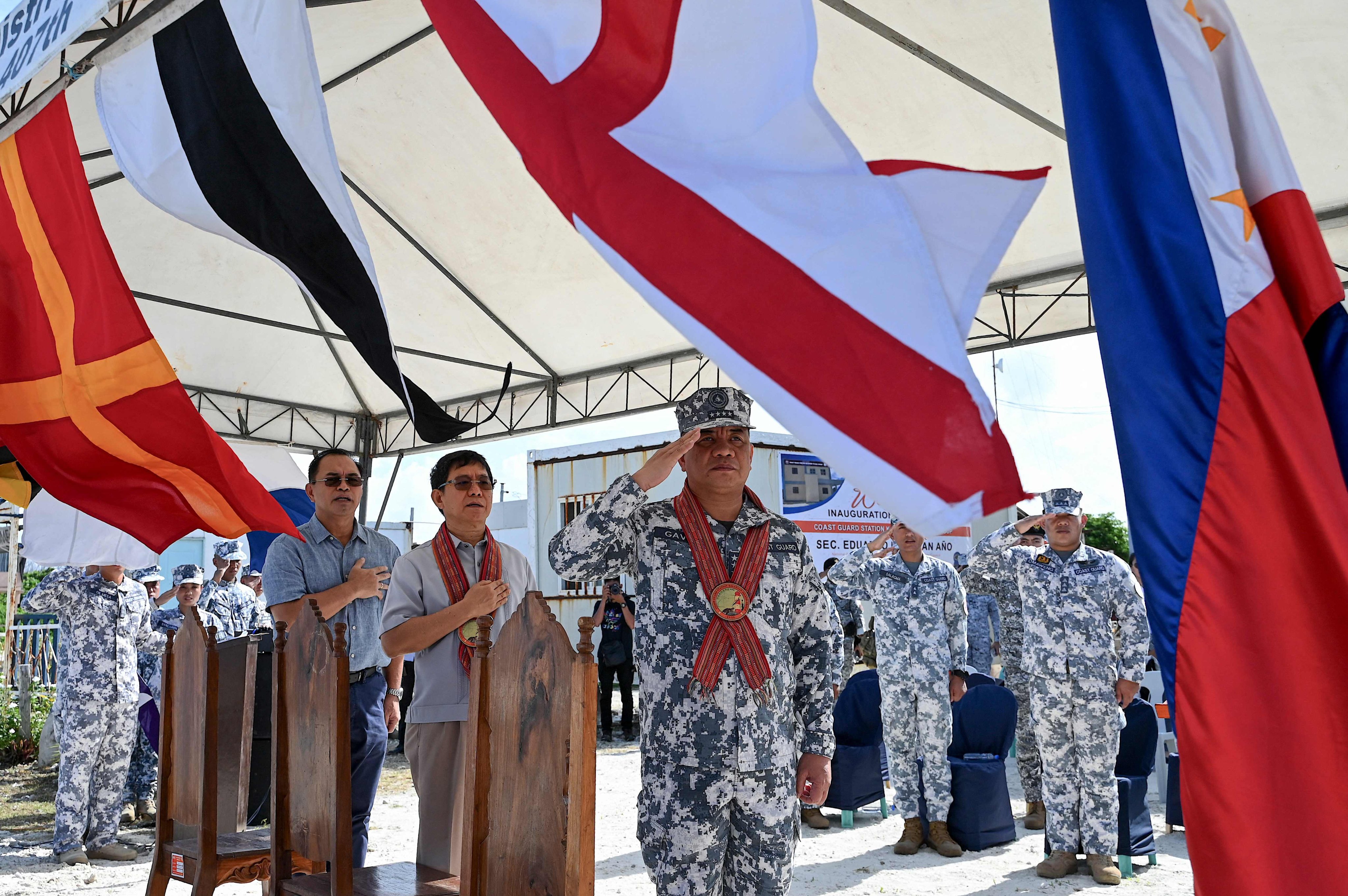 Philippine National Security Adviser Eduardo Ano (middle) observe the Philippine national anthem on Thitu Island. The monitoring station has been built and is expected to be operational early next year. Photo: AFP