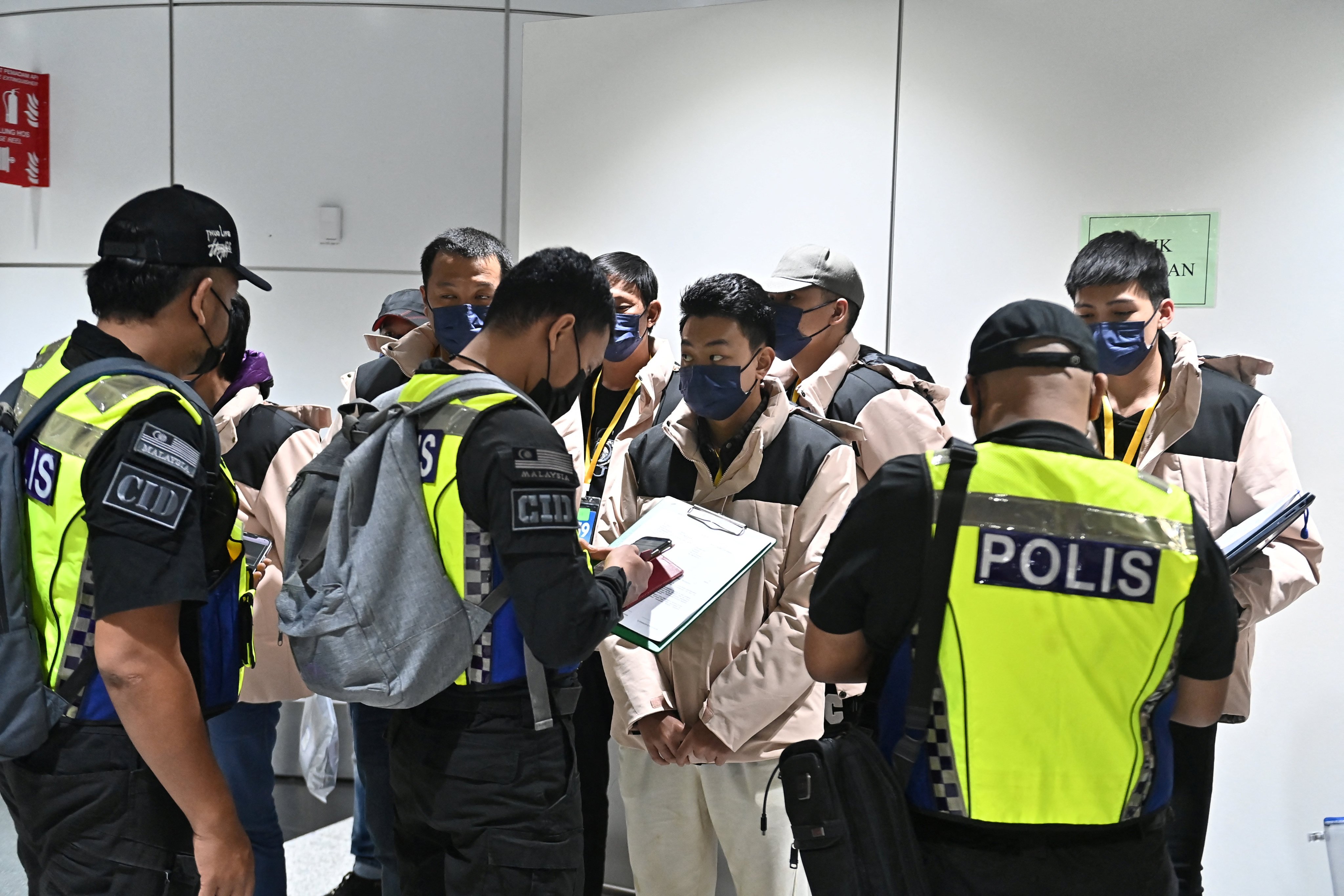 Police officers speak to some of the Malaysian job scam victims after they arrived in Kuala Lumpur on Friday. Photo: Malaysia’s Ministry of Foreign Affairs via Reuters