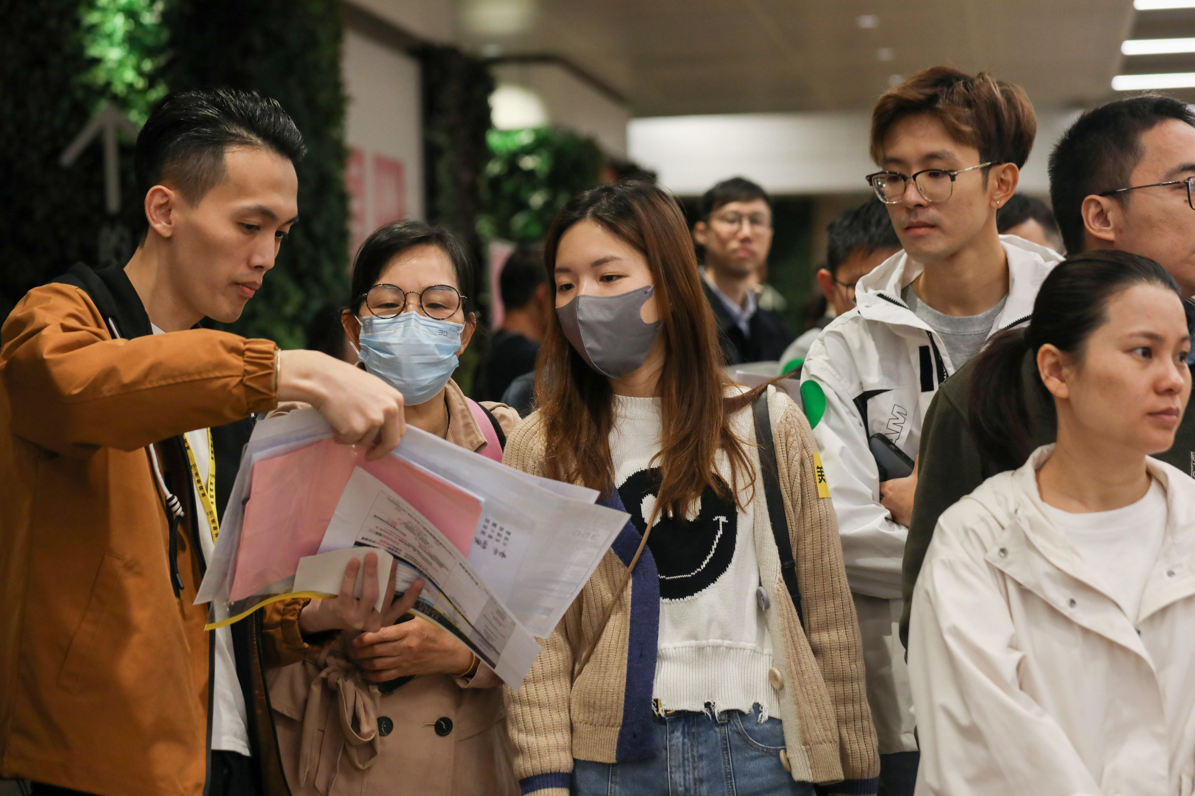 People in a queue check out the price list for flats on offer at Sun Hung Kai Properties’ Yoho West project at the company’s sales office inside the V Walk shopping centre in Sham Shui Po on December 2, 2023. Photo: Xiaomei Chen