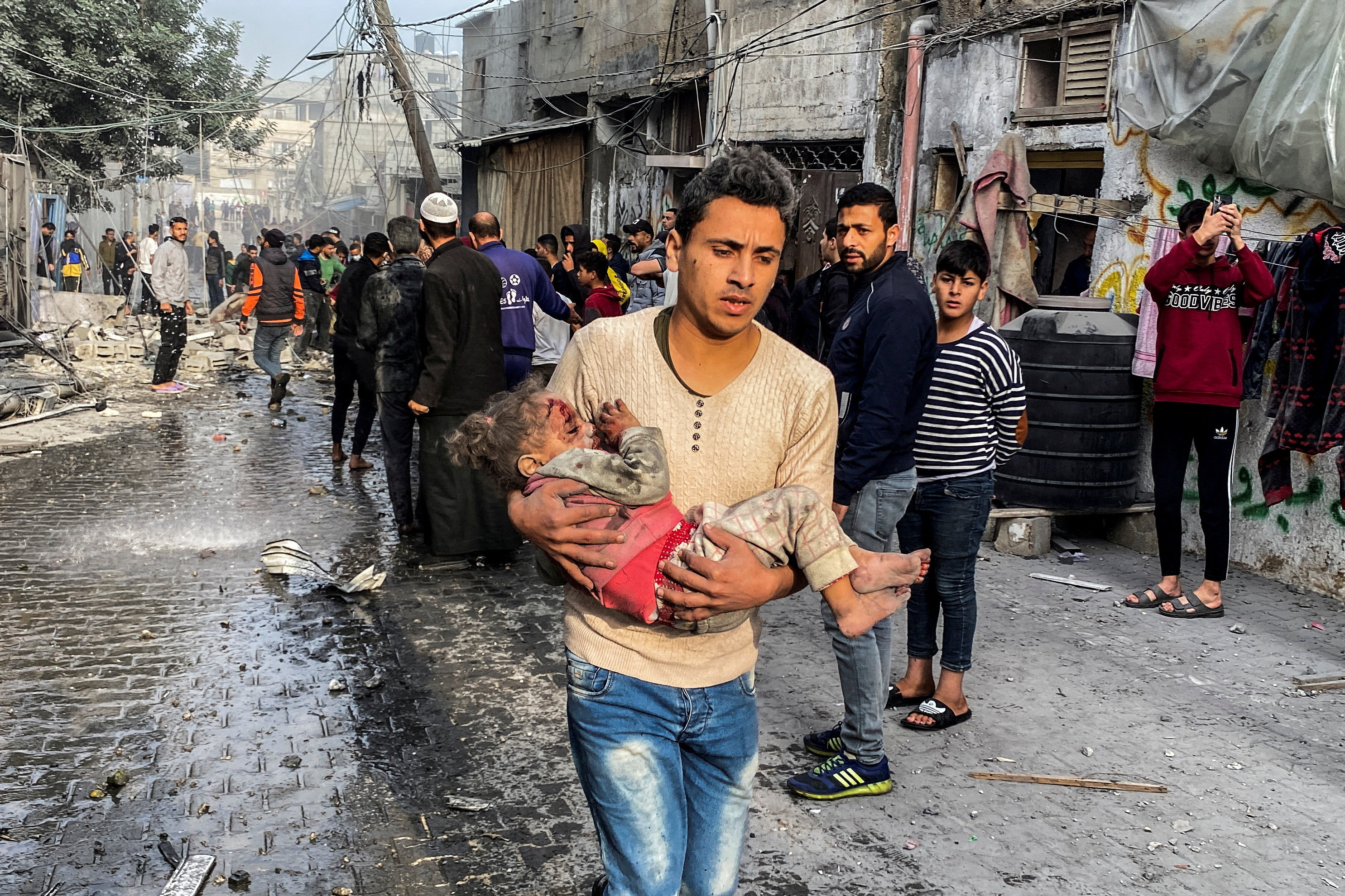 A Palestinian carries a child hurt in an Israeli strike in Rafah, in the southern Gaza Strip on Friday. Photo: Reuters