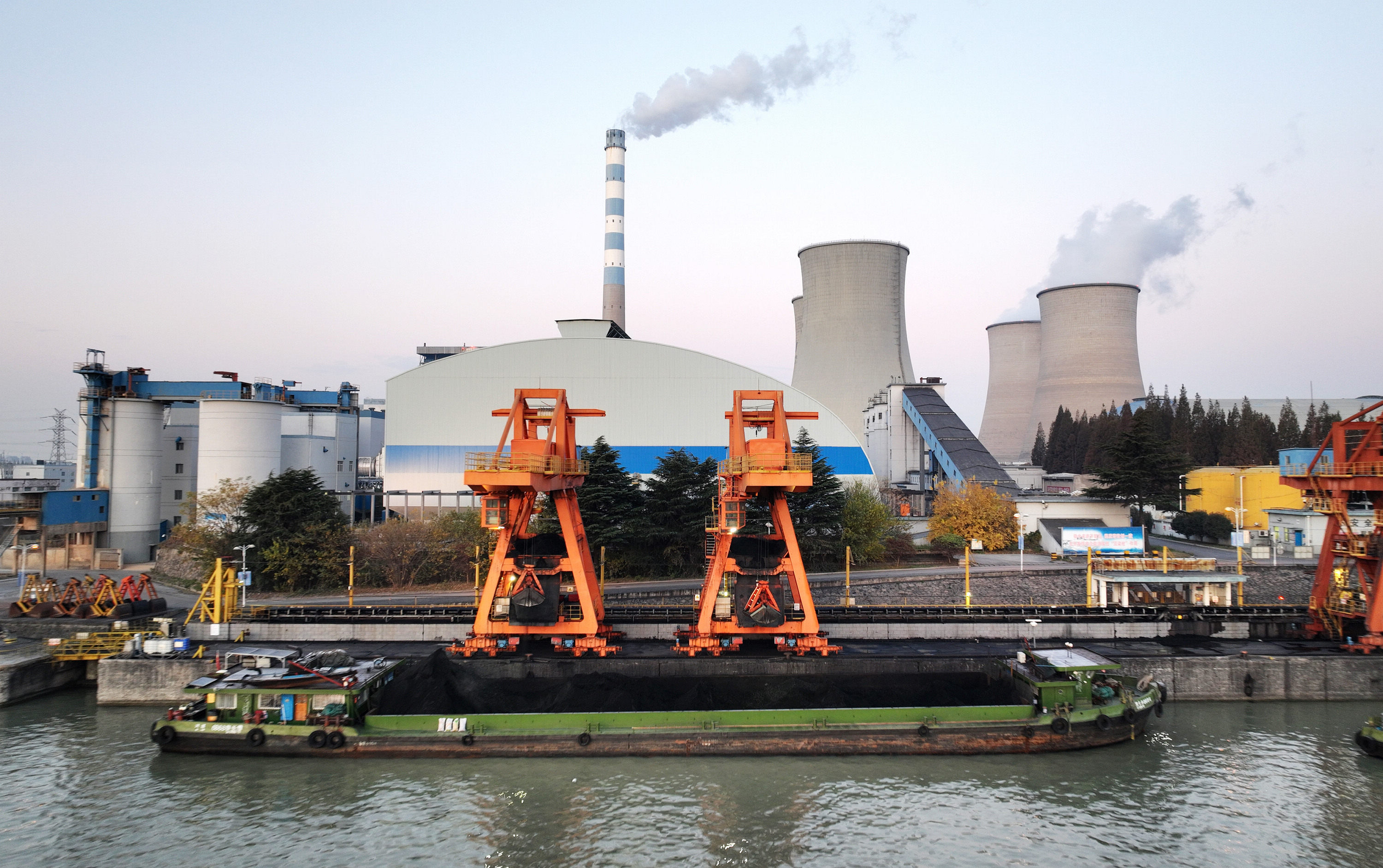 Coal for electricity generation is unloaded from a cargo ship at the port of the Jiangsu Huadian Yangzhou Power Plant along the Beijing-Hangzhou Grand Canal in Yangzhou city, Jiangsu province, on December 2, 2023. Photo: VCG