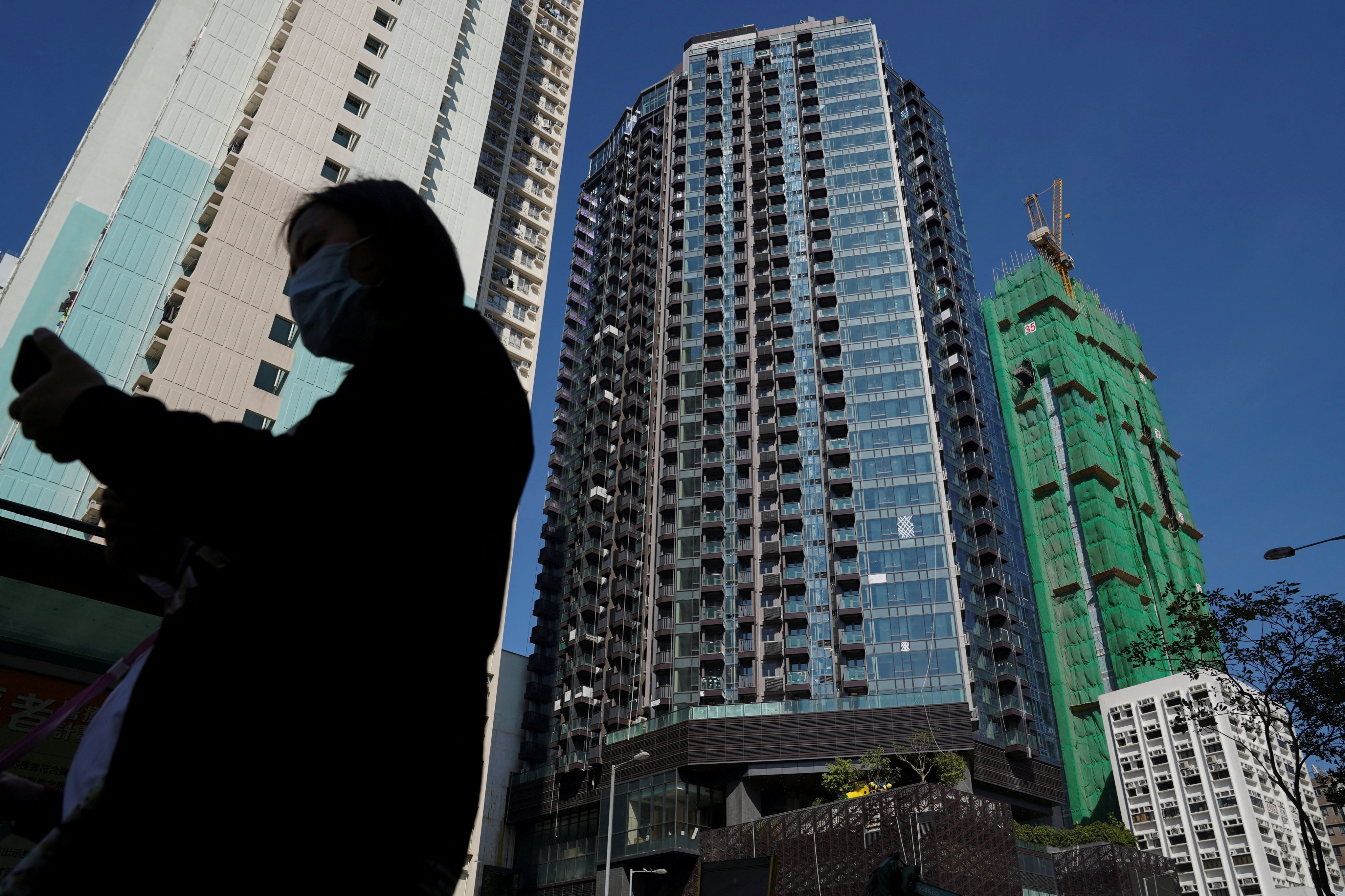 A pedestrian walks past a residential development in Hong Kong in November 2021. Tracking the ratio of average monthly mortgage payment to average wage will give us a better gauge of affordability than the traditional house price-to-income ratio. Photo: Reuters