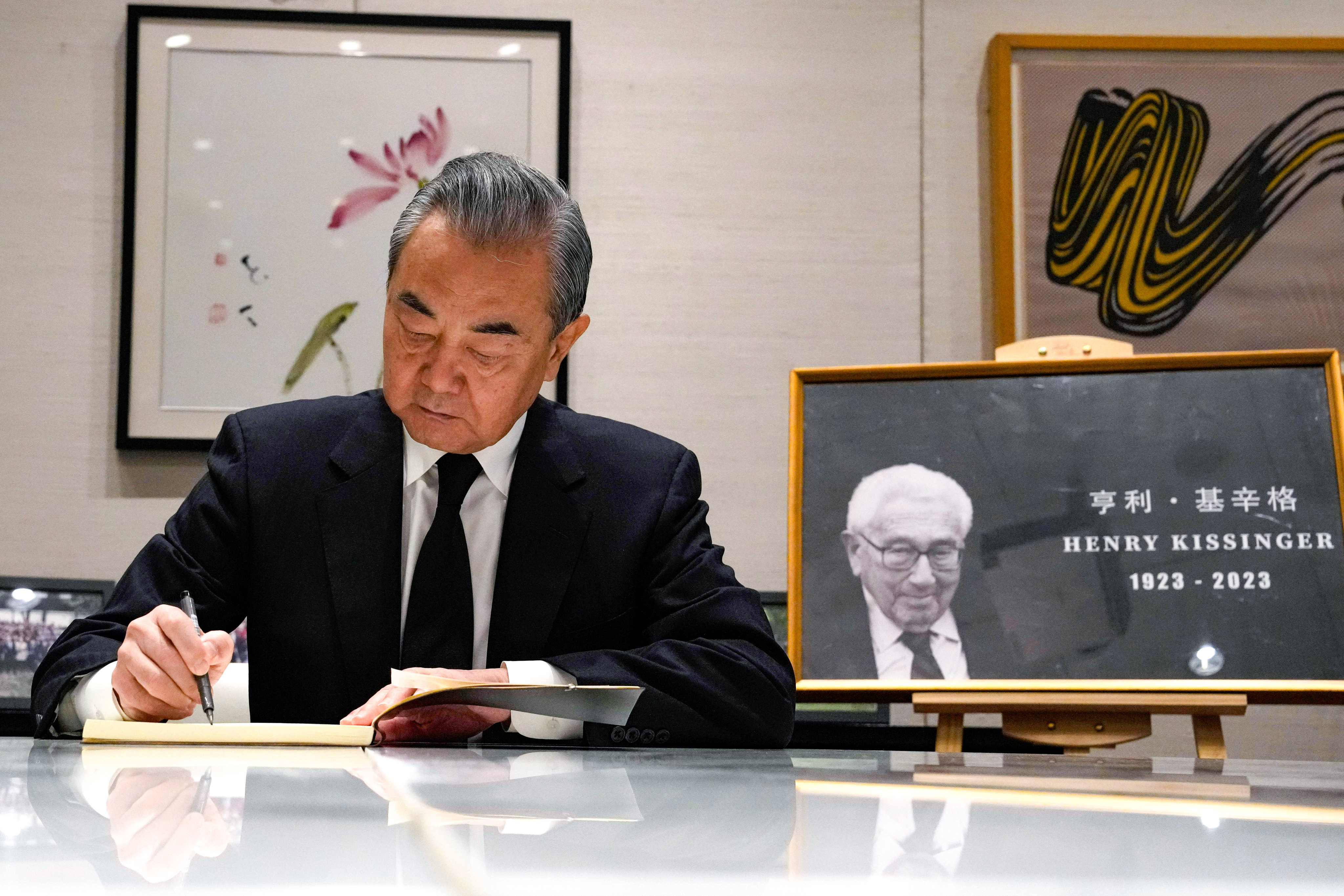 Chinese Foreign Minister Wang Yi signs a condolence book for Henry Kissinger at the US embassy in Beijing on Tuesday. Photo: AP