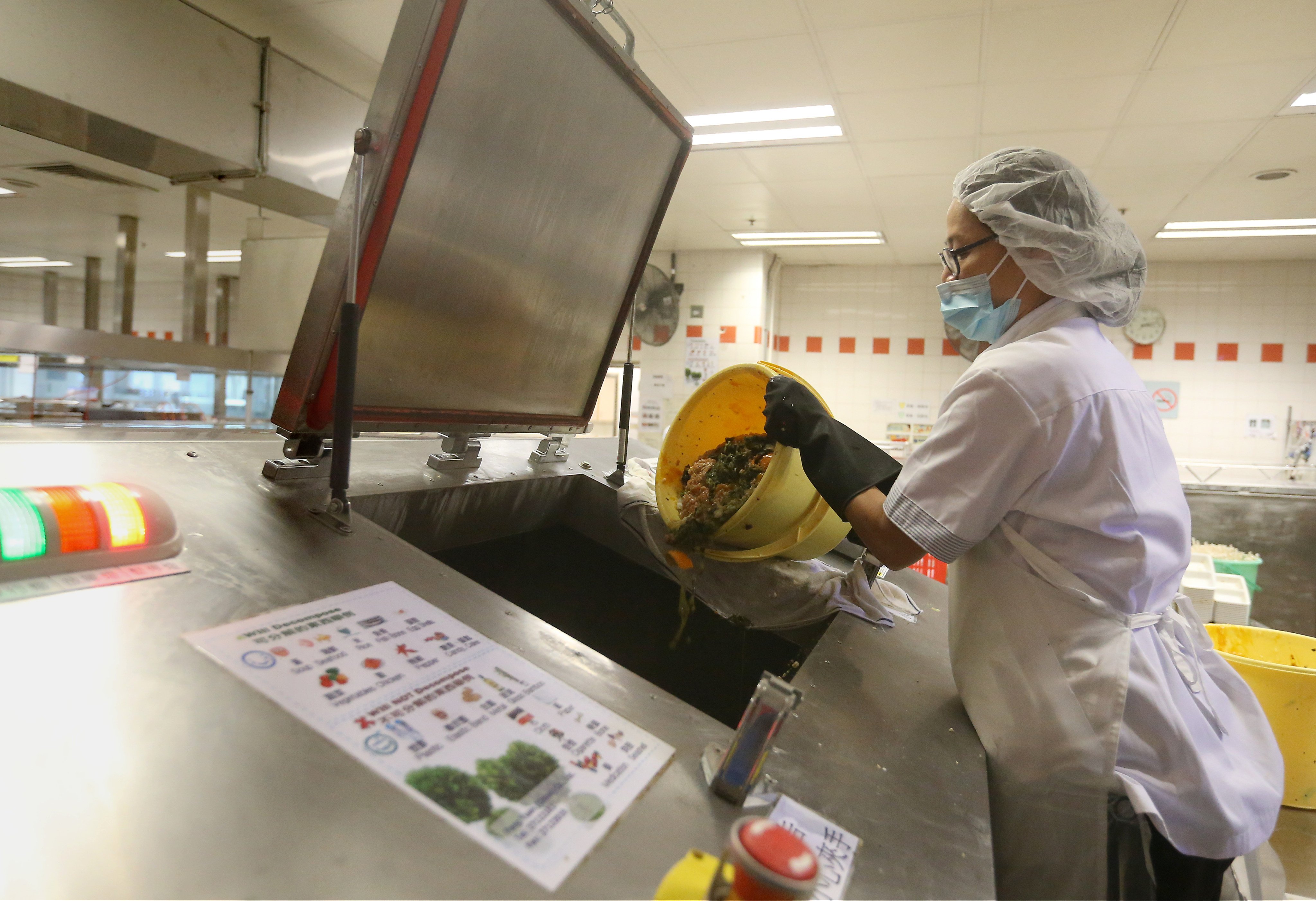 A worker dumps food waste into a machine at Kowloon Hospital. Increasing the recycling of food waste and improving its disposal are seen as essential steps in dealing with problems of rodent infestation around Hong Kong. Photo: K.Y. Cheng