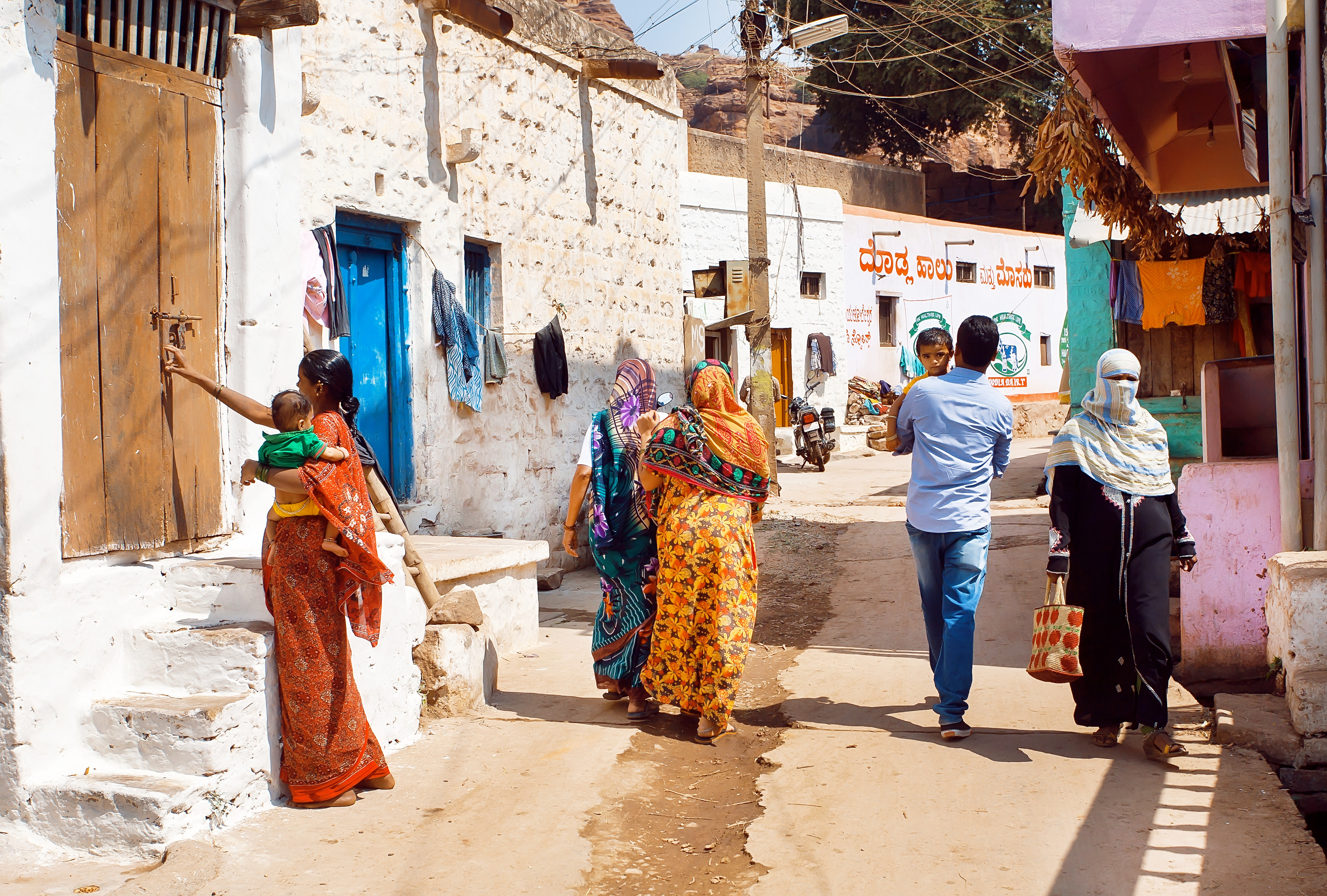 People walk along a narrow street in a small town in Karnataka state. Photo: Shutterstock 