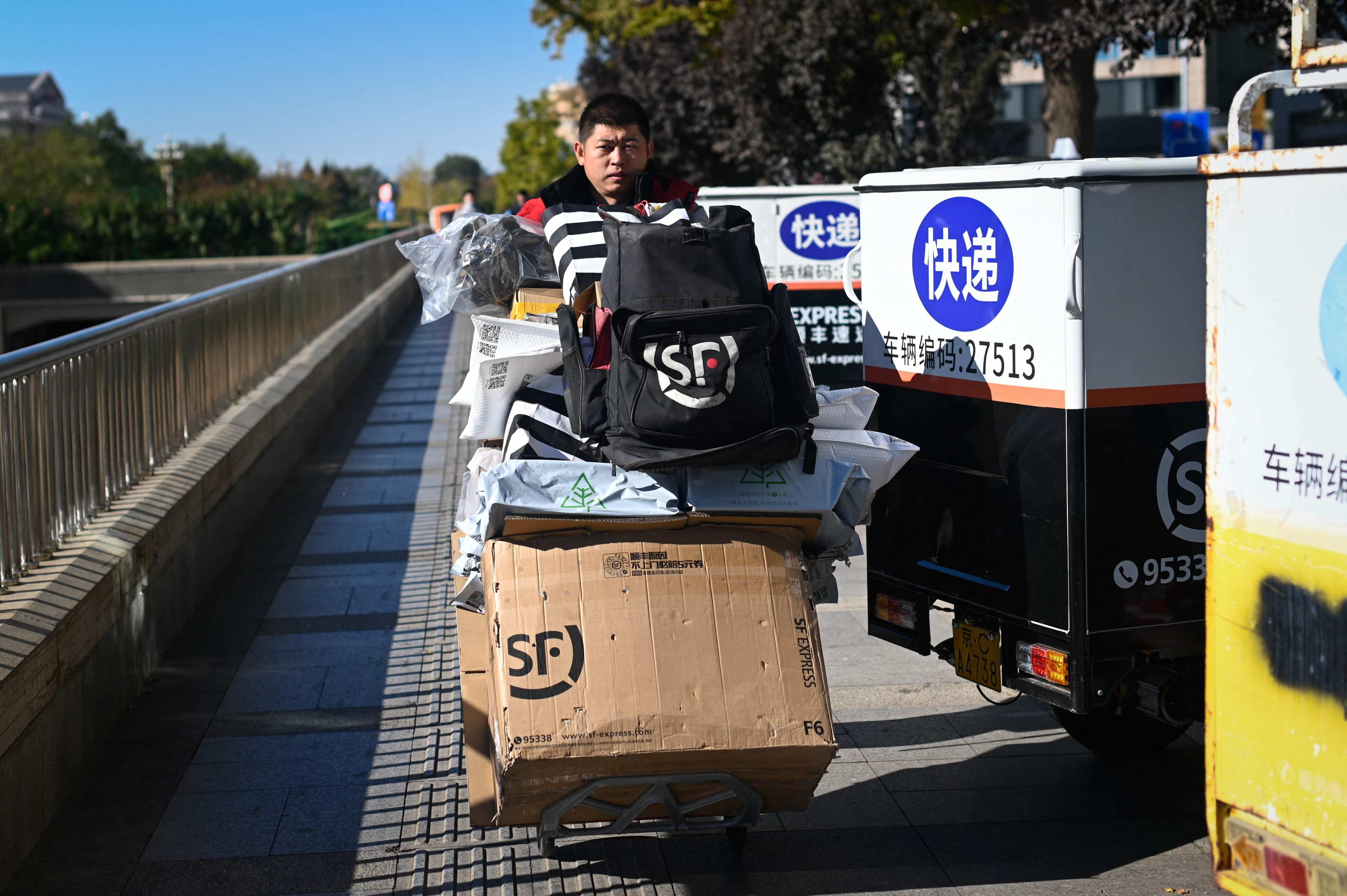 A delivery man pushes a trolley with packages outside a mall during the Singles’ Day shopping festival in Beijing on November 11, 2023. Photo: AFP