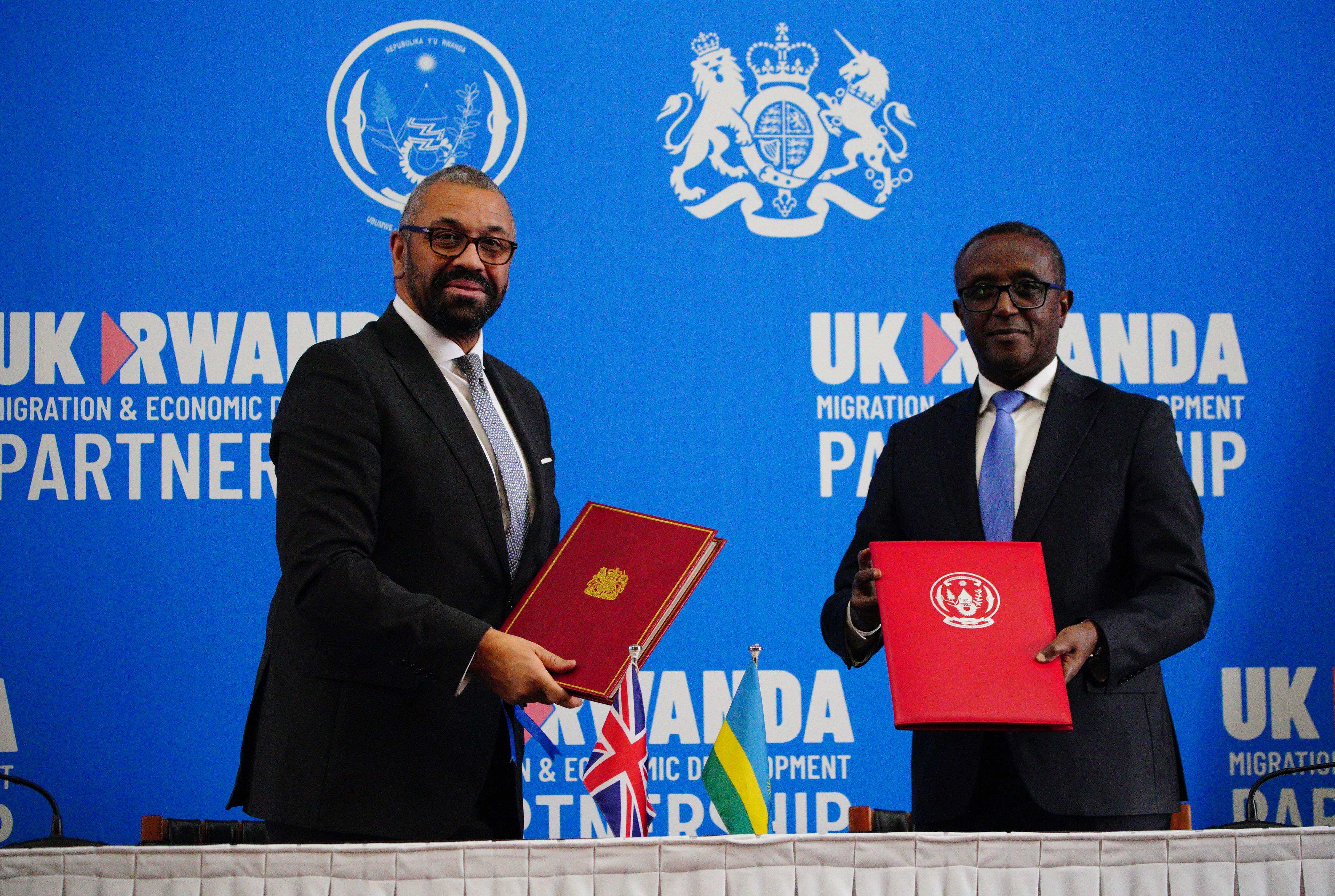 Britain’s Home Secretary James Cleverly (left) and Rwanda’s Foreign Minister Vincent Biruta exchange documents after signing a new treaty, in Kigali on Tuesday. Photo: Pool/AFP