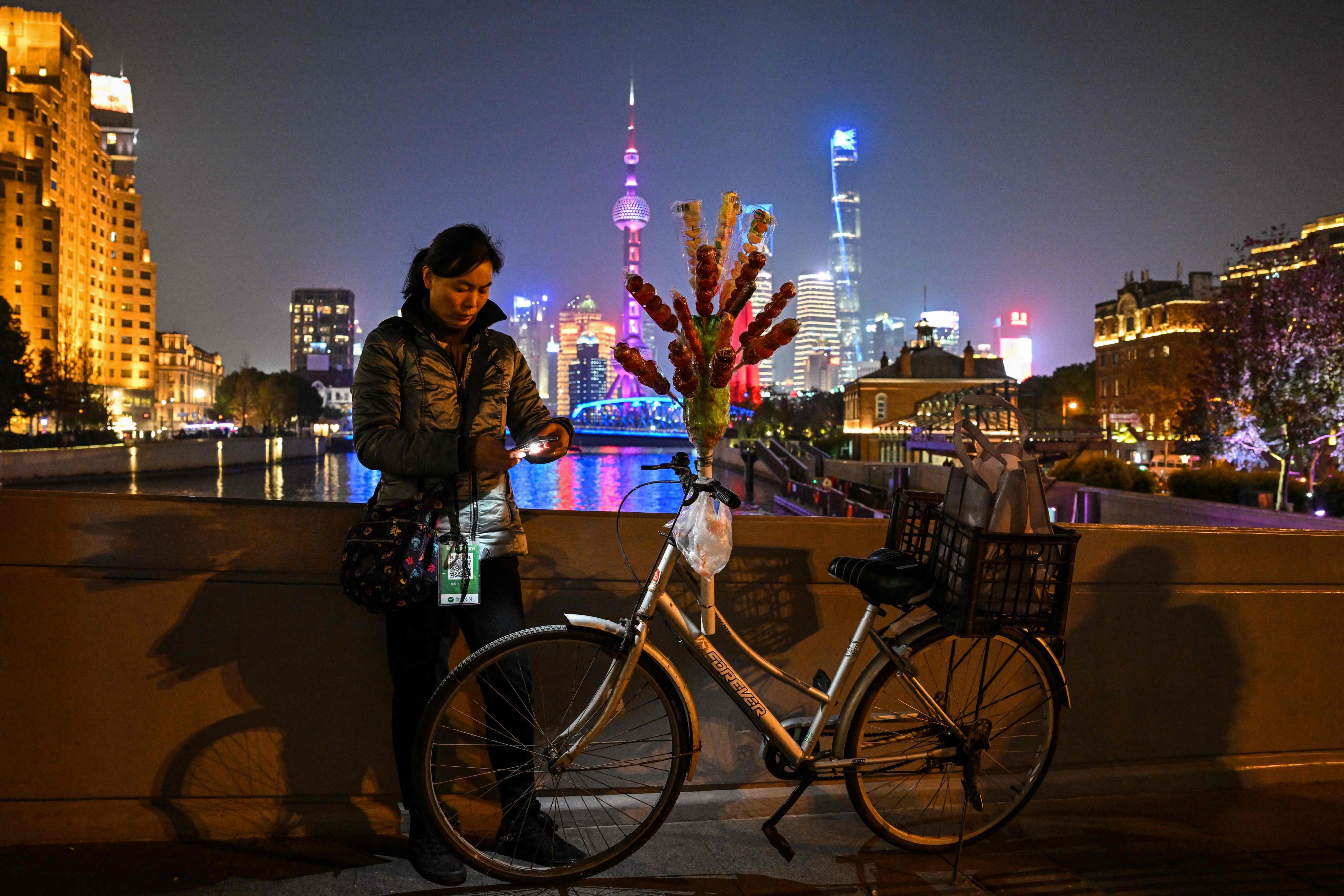 A vendor stands over the Zhapu Road Bridge in the Huangpu district in Shanghai on December 6. China’s drift from the global economic spotlight could give policymakers room to make needed adjustments but also brings risks of its own. Photo: AFP