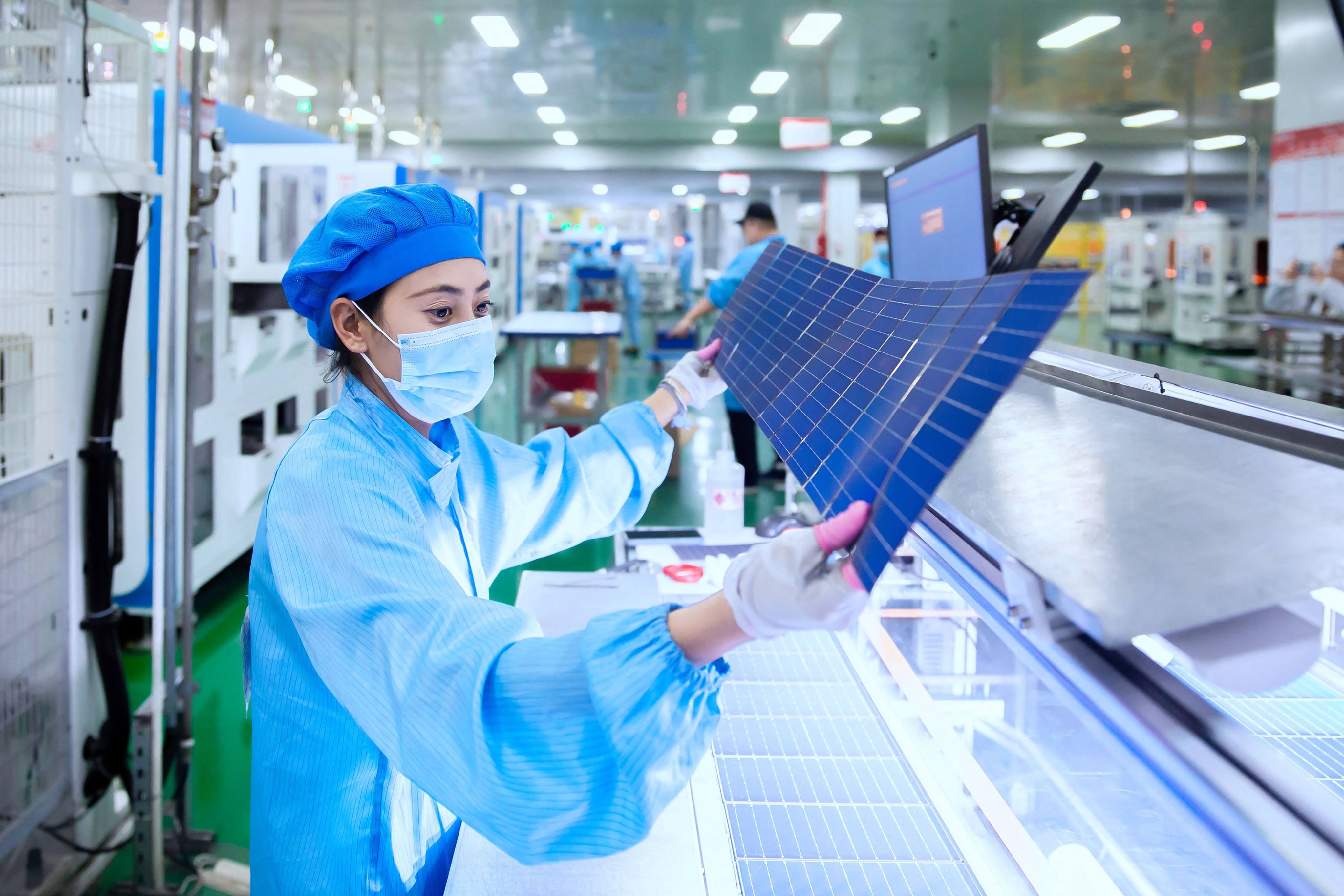 An employee checks solar photovoltaic modules at a factory in Haian in China’s eastern Jiangsu province on November 21, 2023. Photo: AFP