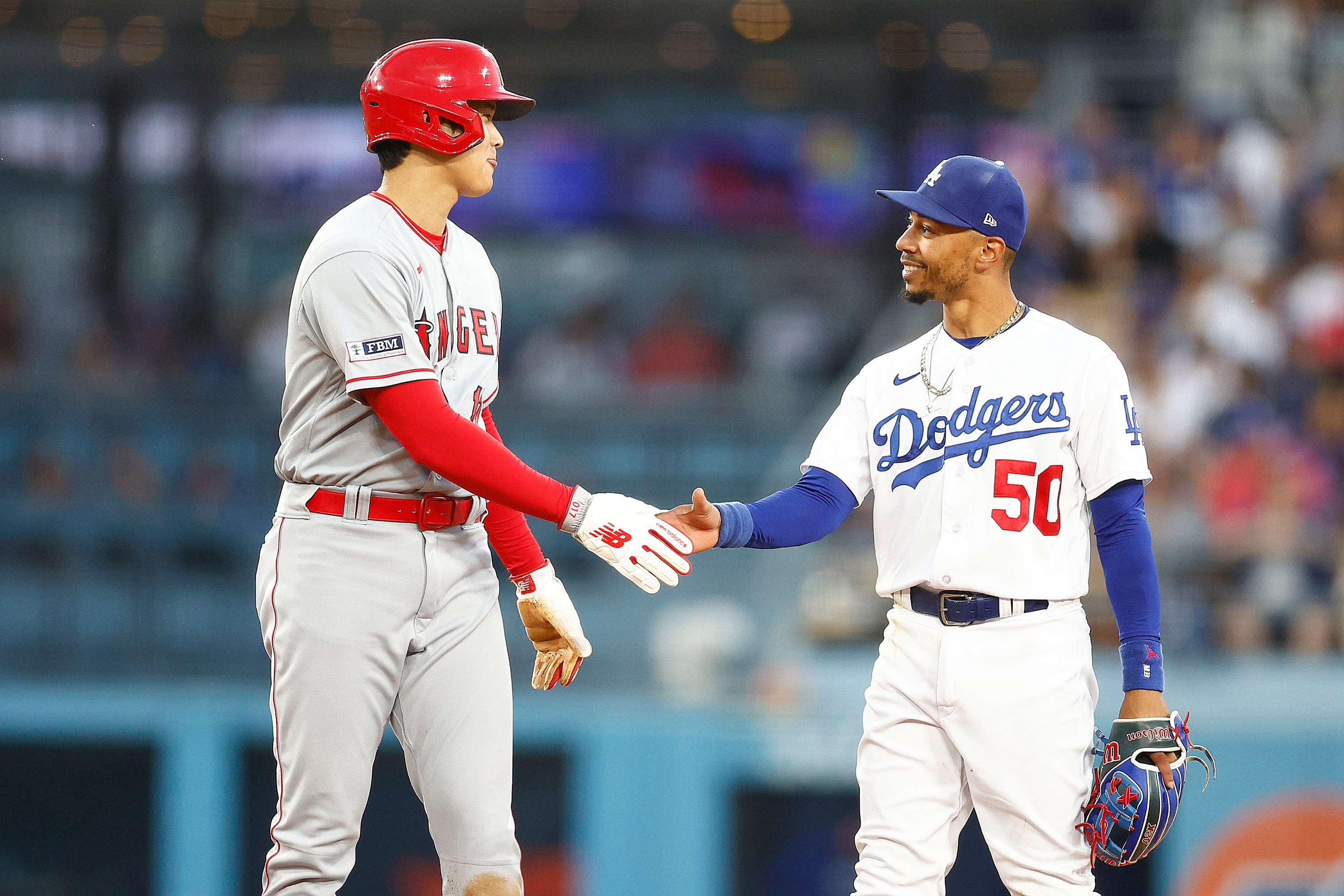 Mookie Betts (50) of the Los Angeles Dodgers and Shohei Ohtani (17) of the Los Angeles Angels shake hands during a game in June. The two cross town rivals will now be teammates following Ohtani’s record contract with the Dodgers. Photo: TNS