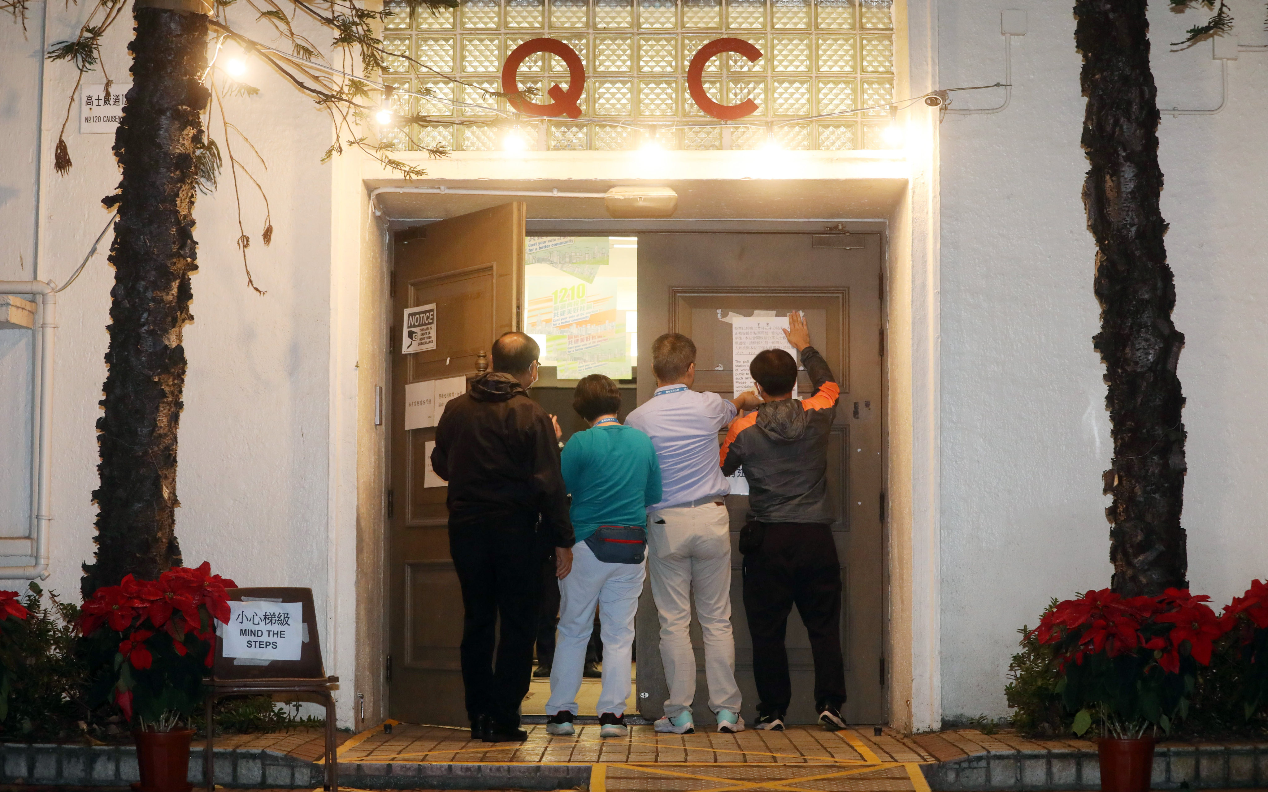 Electoral staff close the polling station at Queen’s College in Causeway Bay at midnight. Photo: Sun Yeung