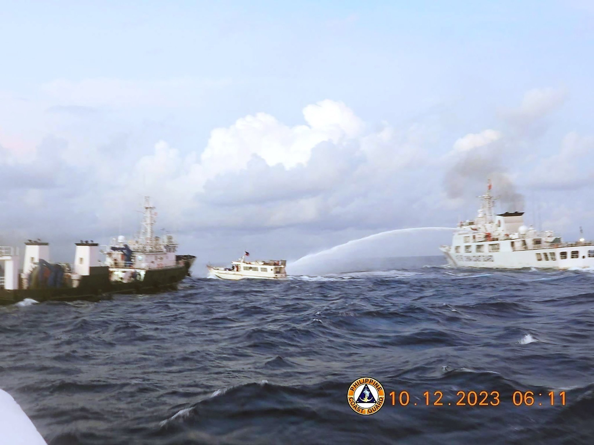 A Chinese coastguard ship (right) fires a water cannon on a supply boat operated by the Philippine Navy on Sunday in this handout photo made available by the Philippine coastguard. Photo: Philippine Coast Guard / Handout via EPA-EFE