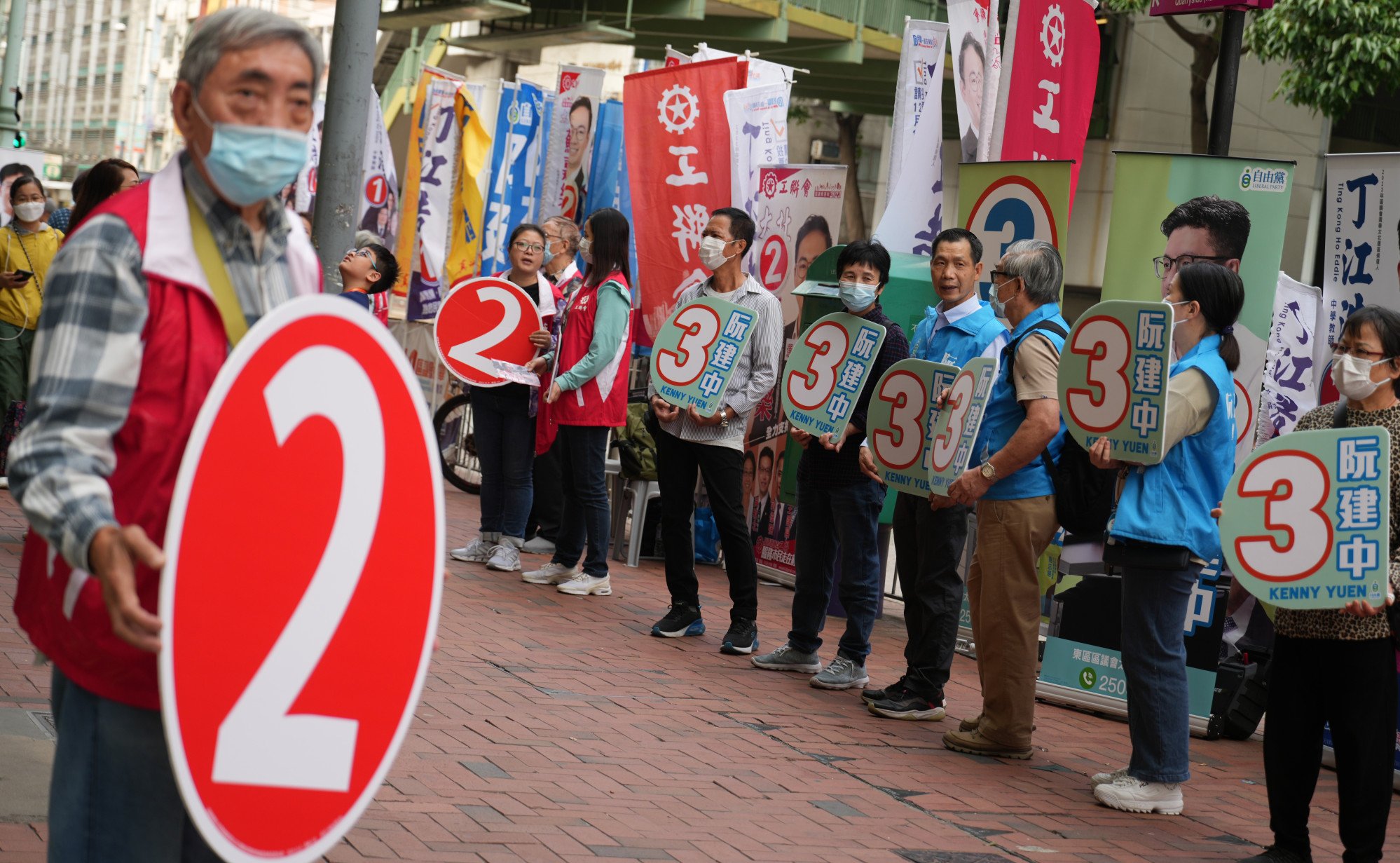 Campaign teams canvas for votes in Quarry Bay. Political analyst Lau Siu-kai he expected the central government would accept a turnout rate of about 30 per cent for the poll. Photo: Sam Tsang