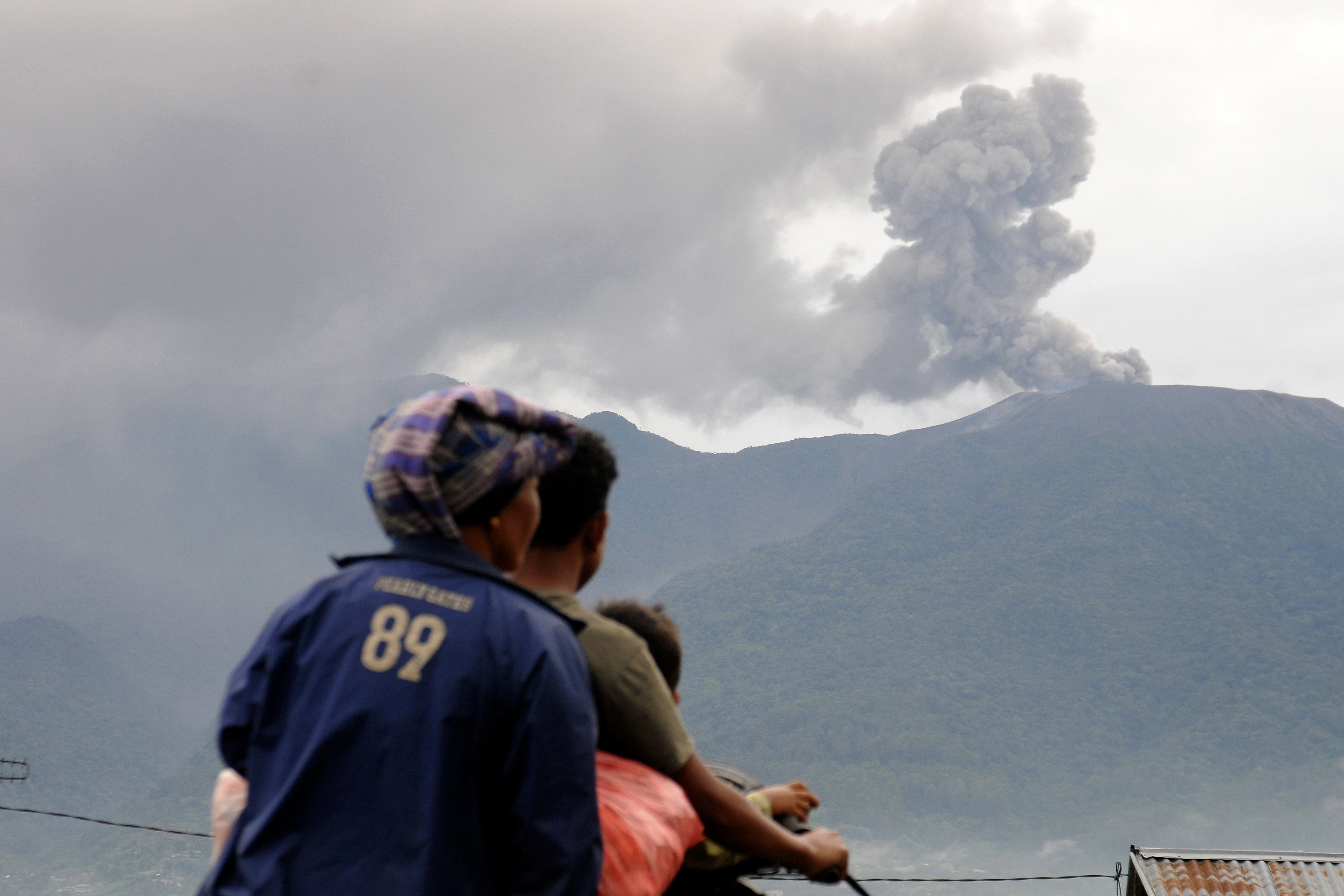 Motorists in West Sumatra watch from a distance as Mount Marapi erupts on December 4. Photo: AP