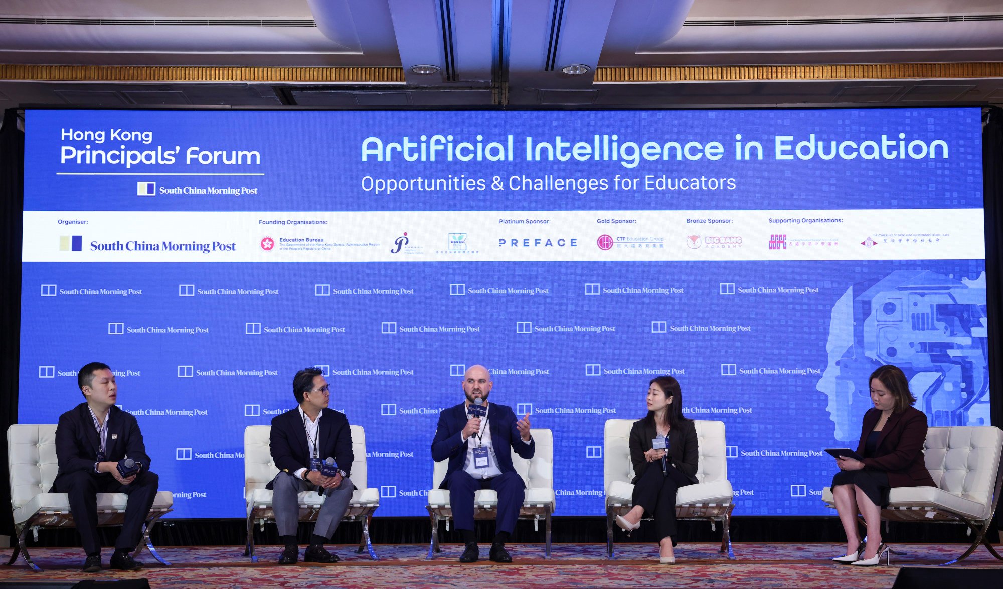 A panel of five individuals discusses artificial intelligence in education at the Hong Kong Principals’ Forum, with a large digital screen behind them displaying the forum’s theme and sponsors.