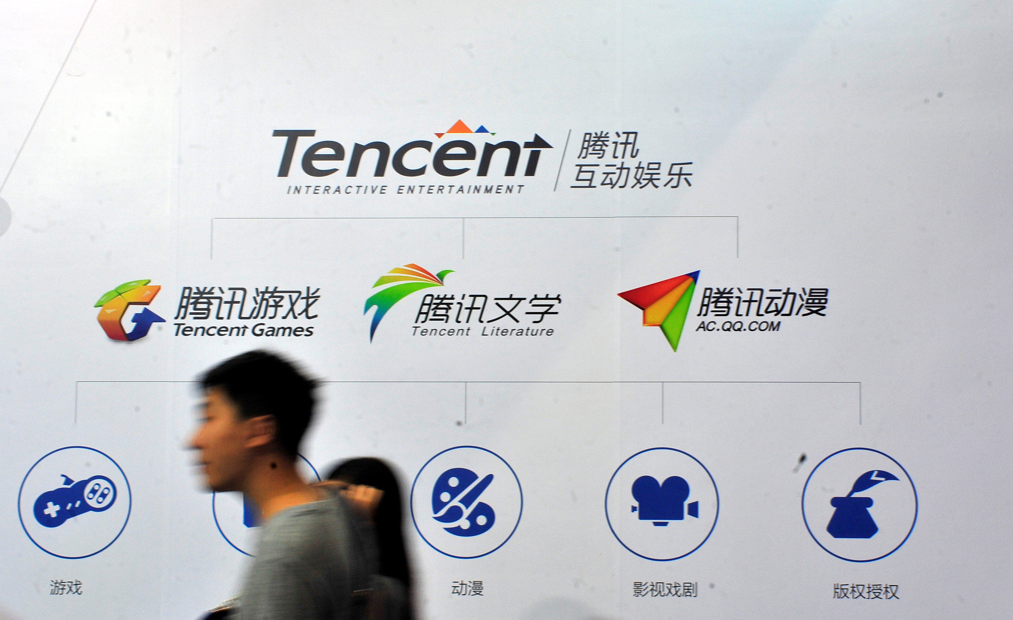People walk past a logo of Tencent Literature during a book fair in Guangzhou, China August 17, 2014. Photo: Reuters