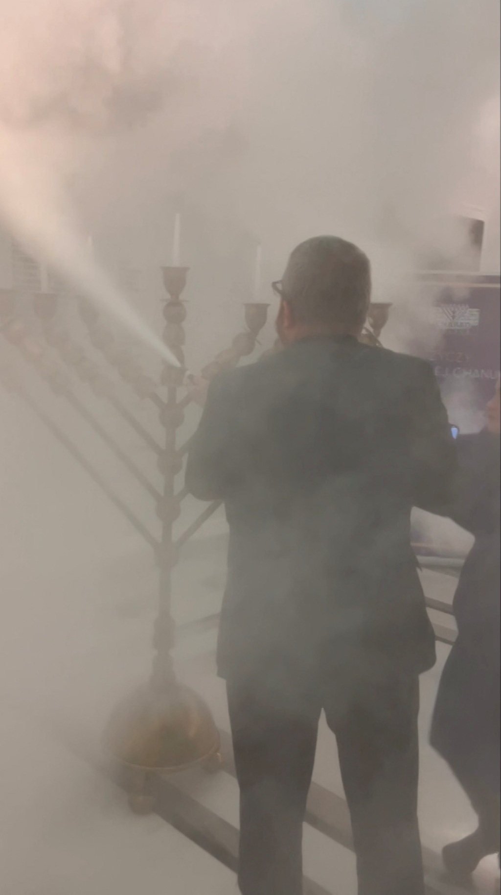 Polish lawmaker Grzegorz Braun holds a fire extinguisher to put out Hanukkah candles at the parliament in Warsaw on Tuesday. Photo: TVN24 via Reuters