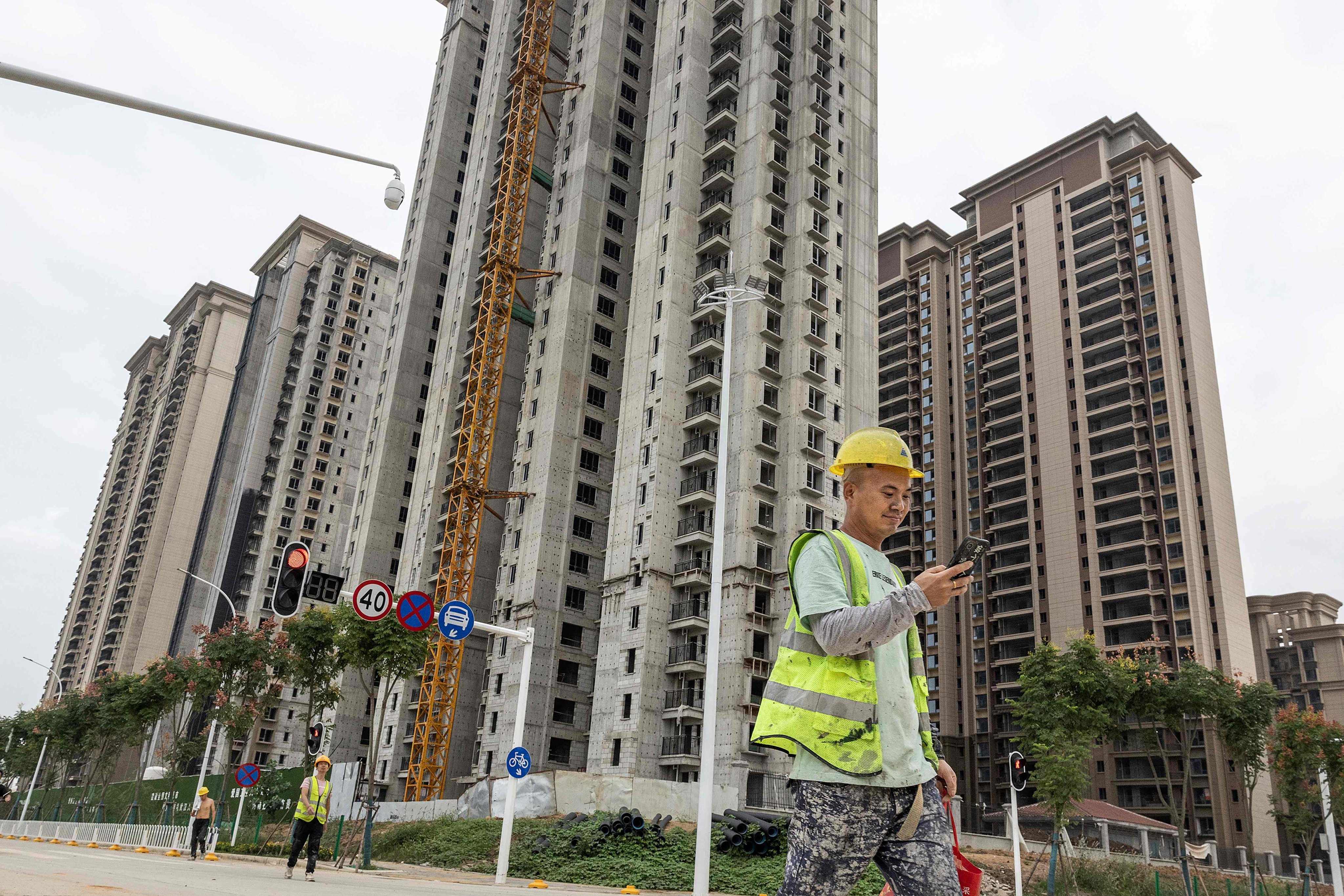 A worker walks past a housing complex under construction by Chinese property developer Evergrande in Wuhan, in China’s central Hubei province, on September 28, 2023. Photo: AFP