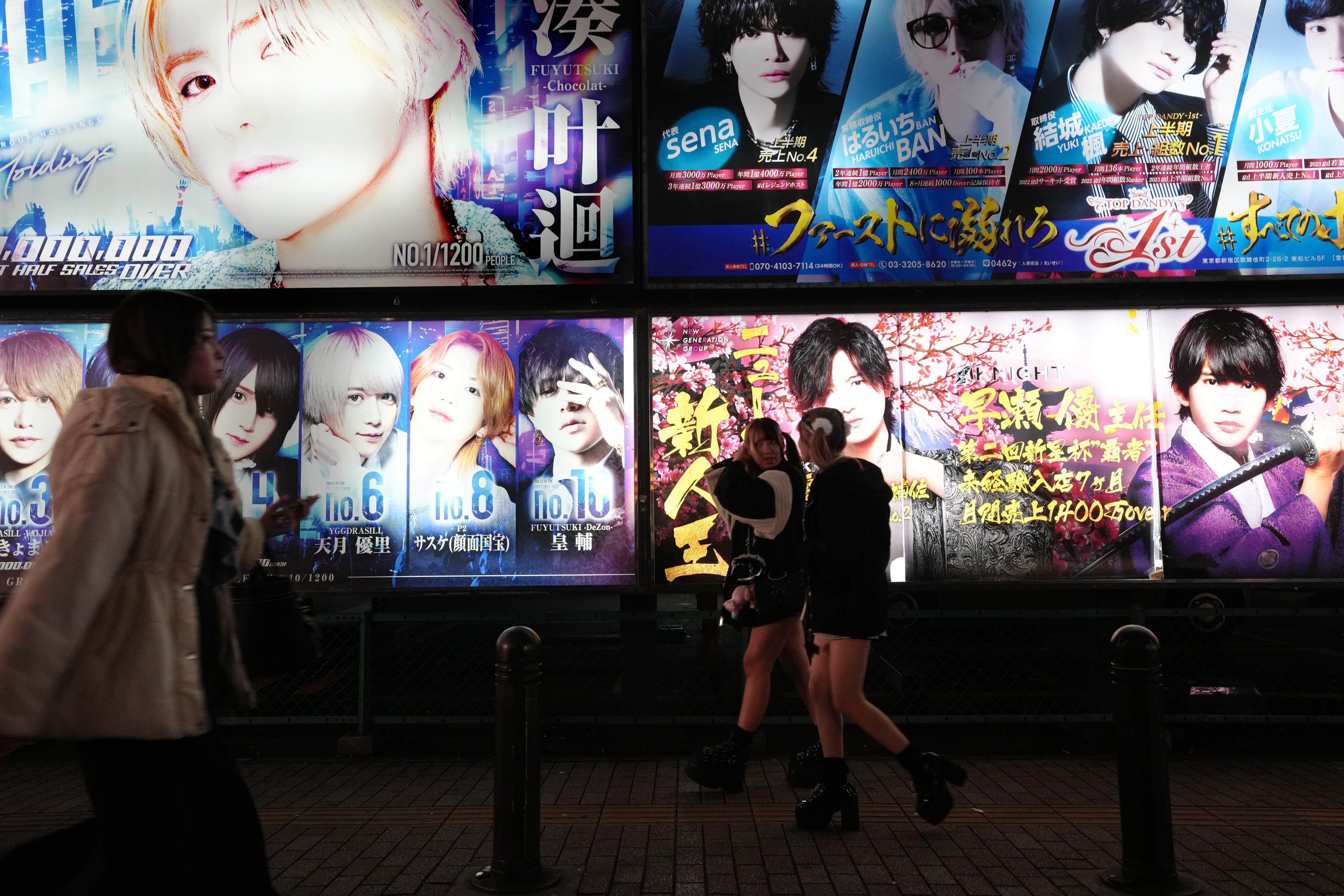 Pedestrians walk past a billboard of a host club at Kabukicho in Tokyo’s Shinjuku district. Photo: EPA-EFE