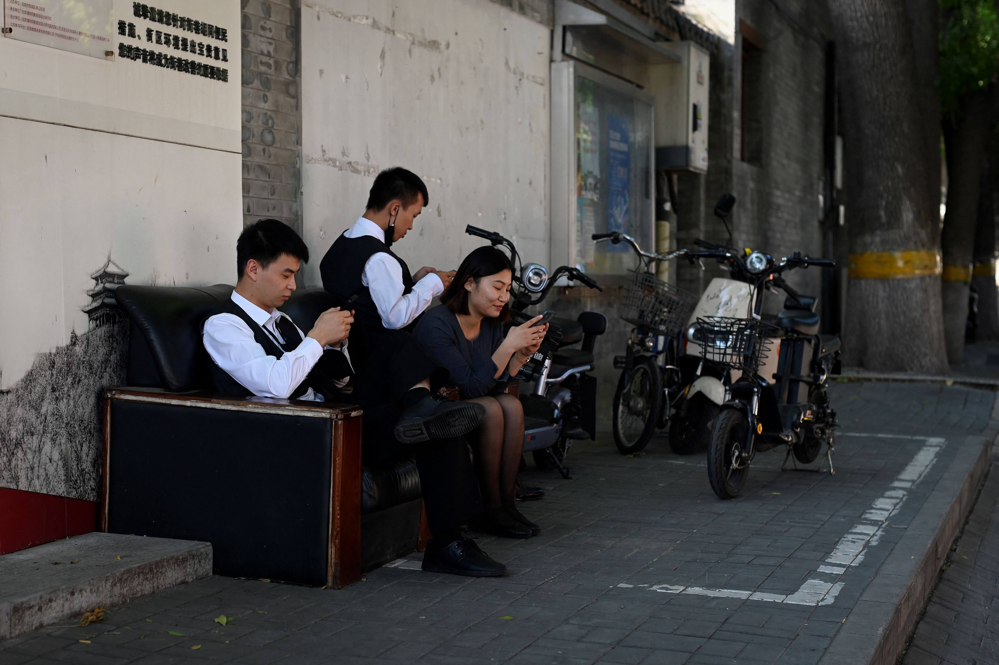 A group of people use their mobile phones to play online video games in Beijing, September 21, 2022. Photo: AFP
