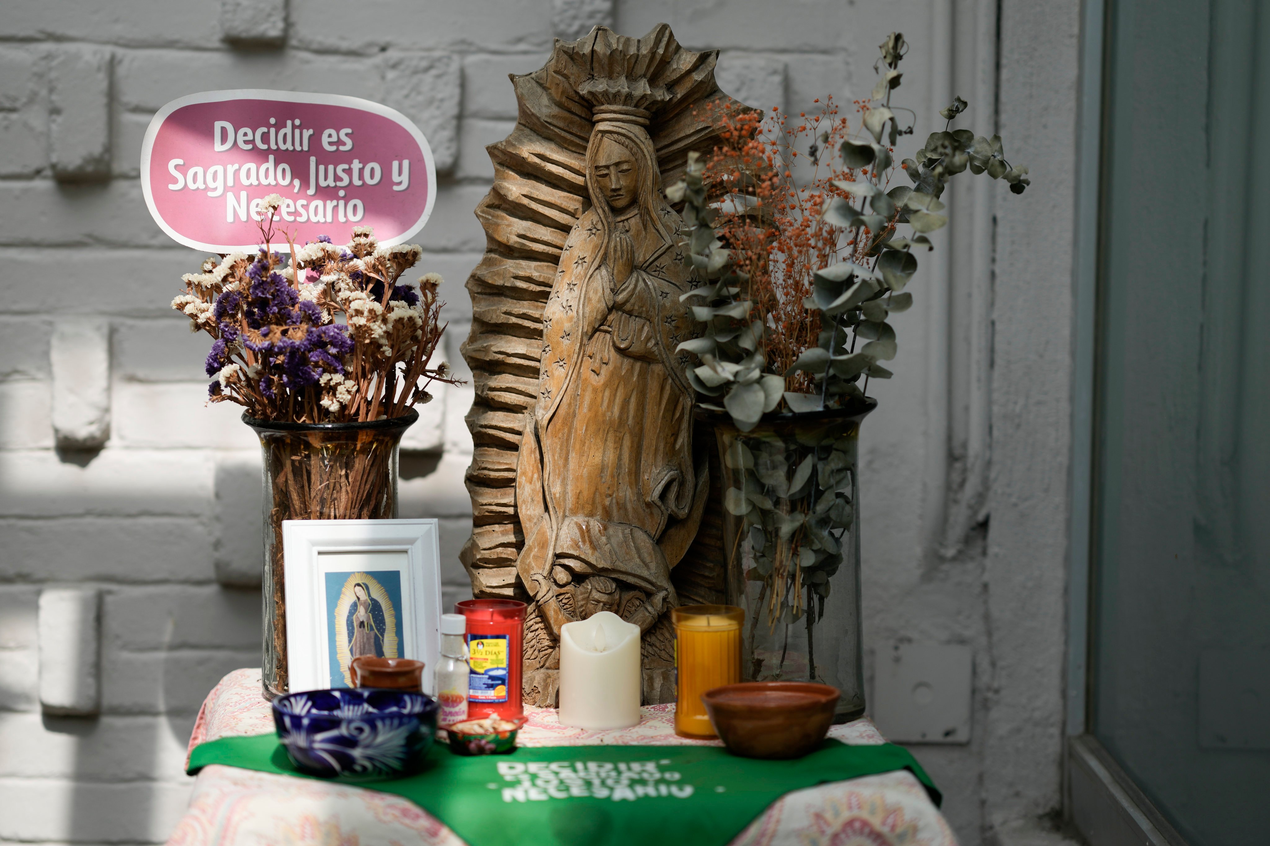 A green scarf with a message that reads in Spanish: “To decide is sacred, just and necessary” adorns an altar to the Virgin Mary, in the office of the Catholics for the Right to Decide, in Mexico City. Photo: AP