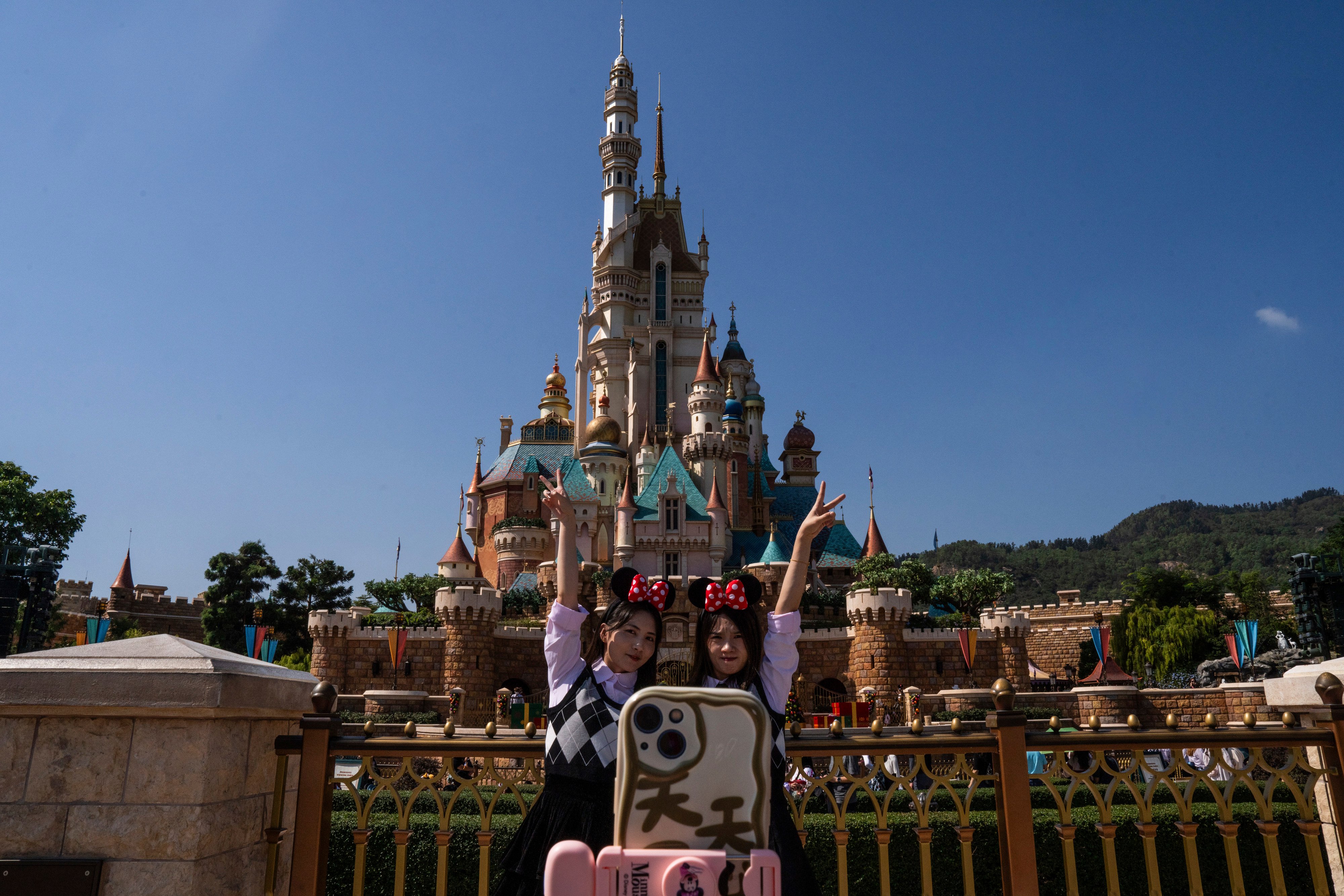 Visitors pose for photographs in front of the Castle of Magical Dreams at Hong Kong Disneyland on November 20. Hong Kong Disneyland is the smallest Disney resort campus in the world. Photo: AP