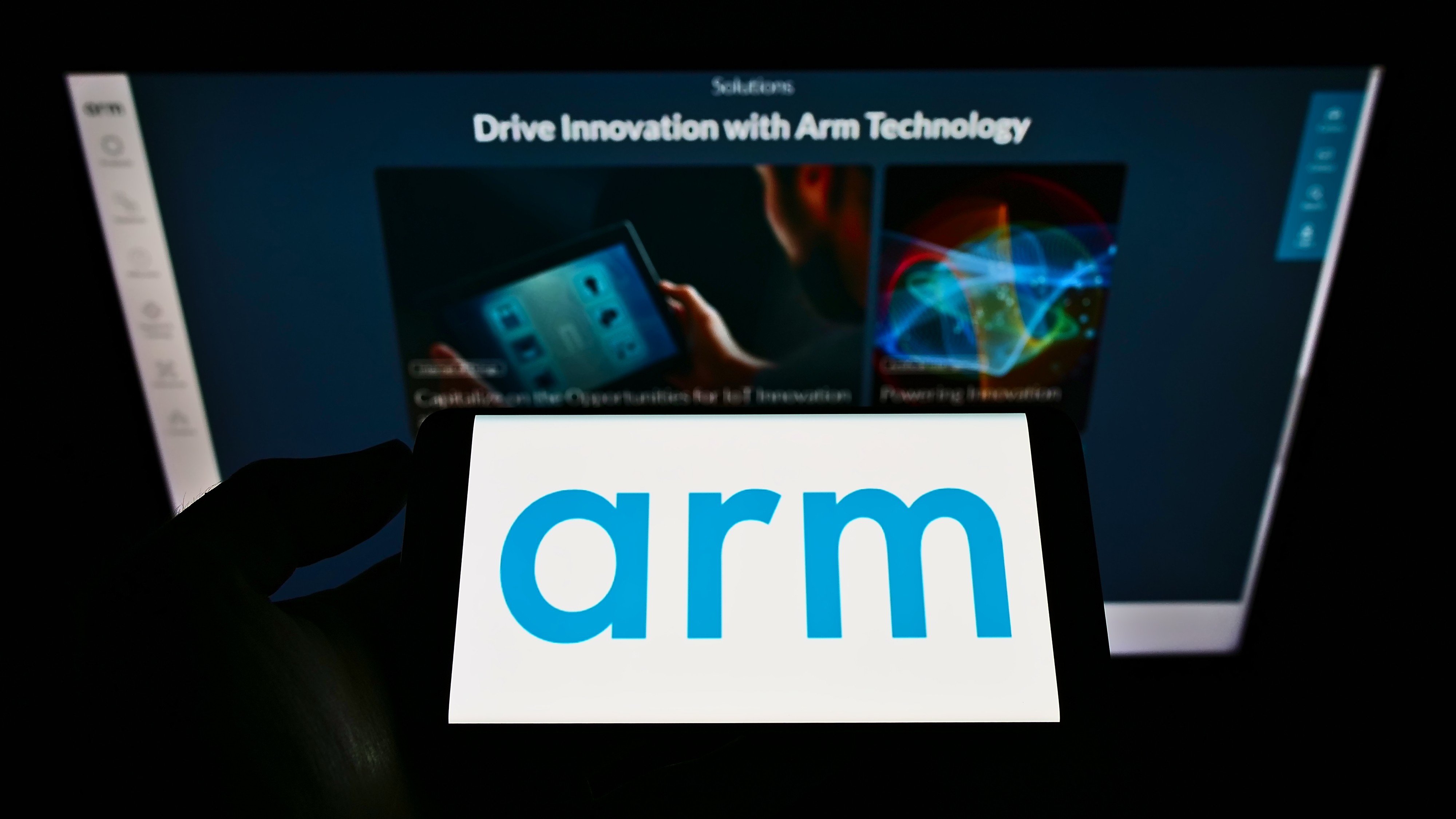 The logo of British semiconductor company Arm seen on a smartphone screen in front of a business webpage. Photo: Shutterstock