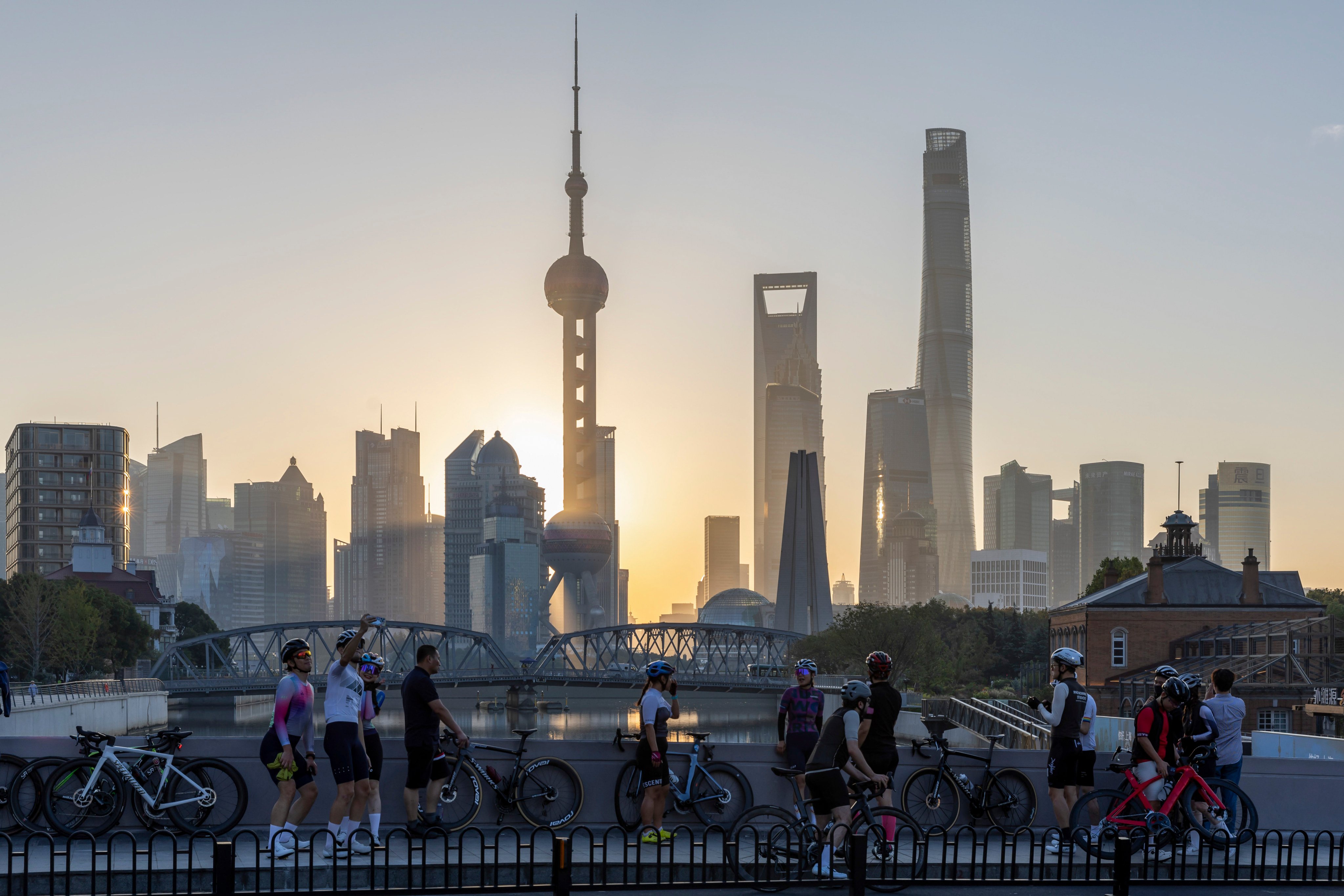 Cyclists rest against the skylines in Pudong, Shanghai on November 3. Photo: AP