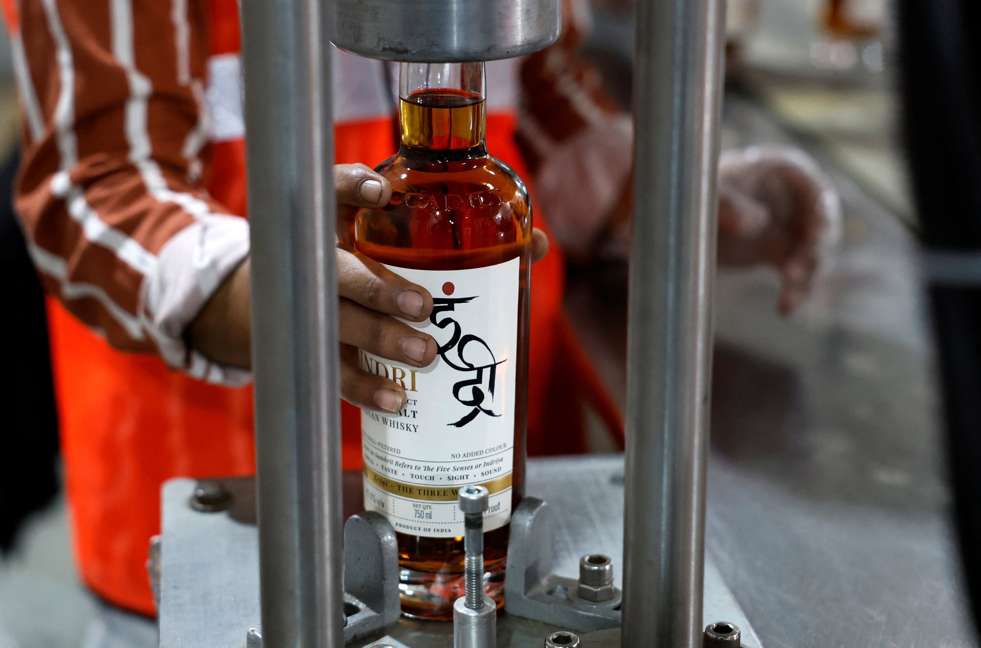 A worker places a whisky bottle to be capped at Piccadily Distilleries in India. Single malt whisky made in India, a big consumer of the distilled spirit, is making waves at home and abroad. Photo: Reuters