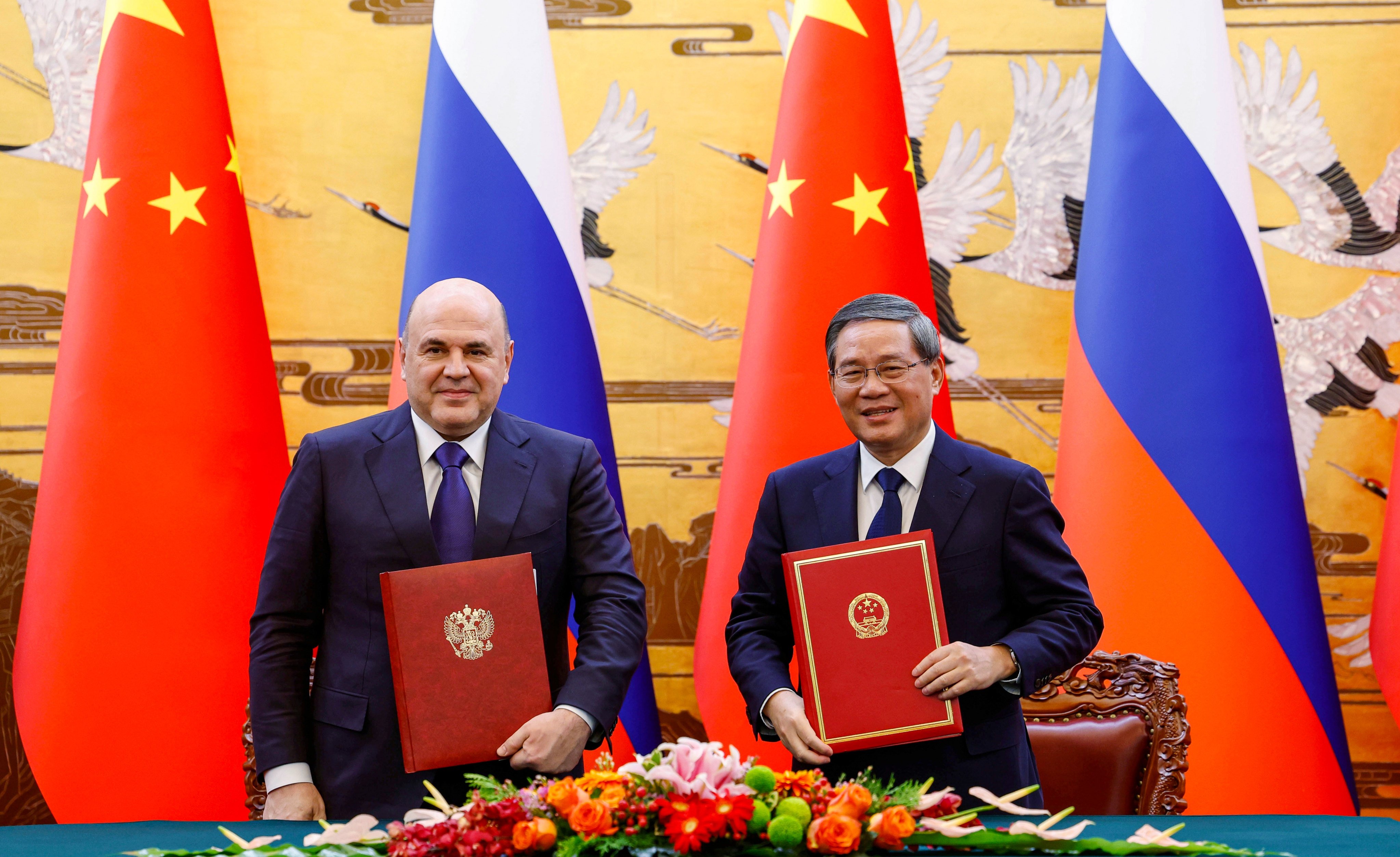 Russian Prime Minister Mikhail Mishustin (left) and Chinese Premier Li Qiang attend a signing ceremony during a meeting in Beijing on Tuesday. Photo: EPA-EFE