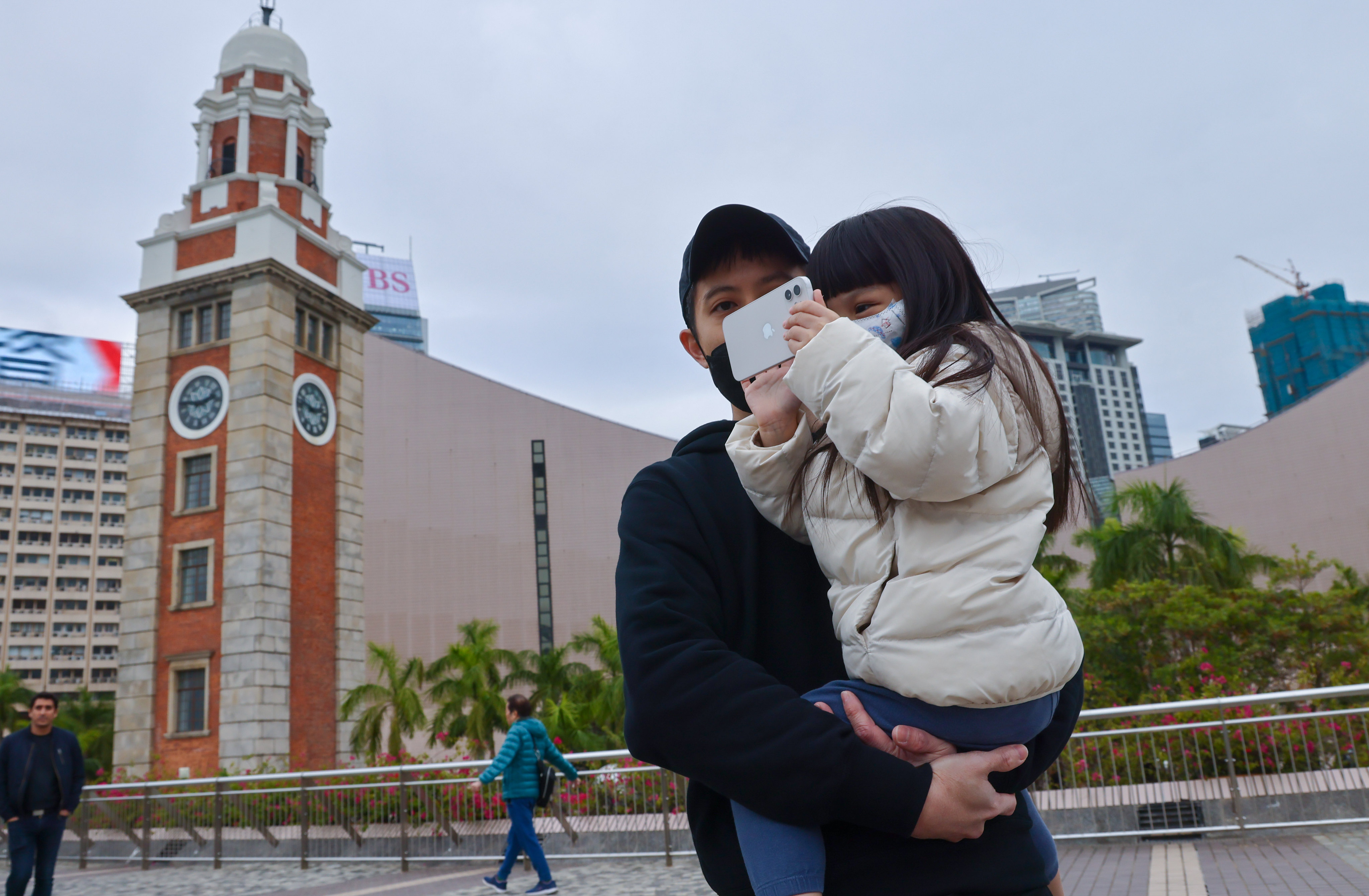 Residents are wrapped up against the chill in Tsim Sha Tsui. A cold weather warning signal has been in force since 4.20pm on Wednesday, with the government opening temporary shelters across the city for those in need. Photo: Dickson Lee
