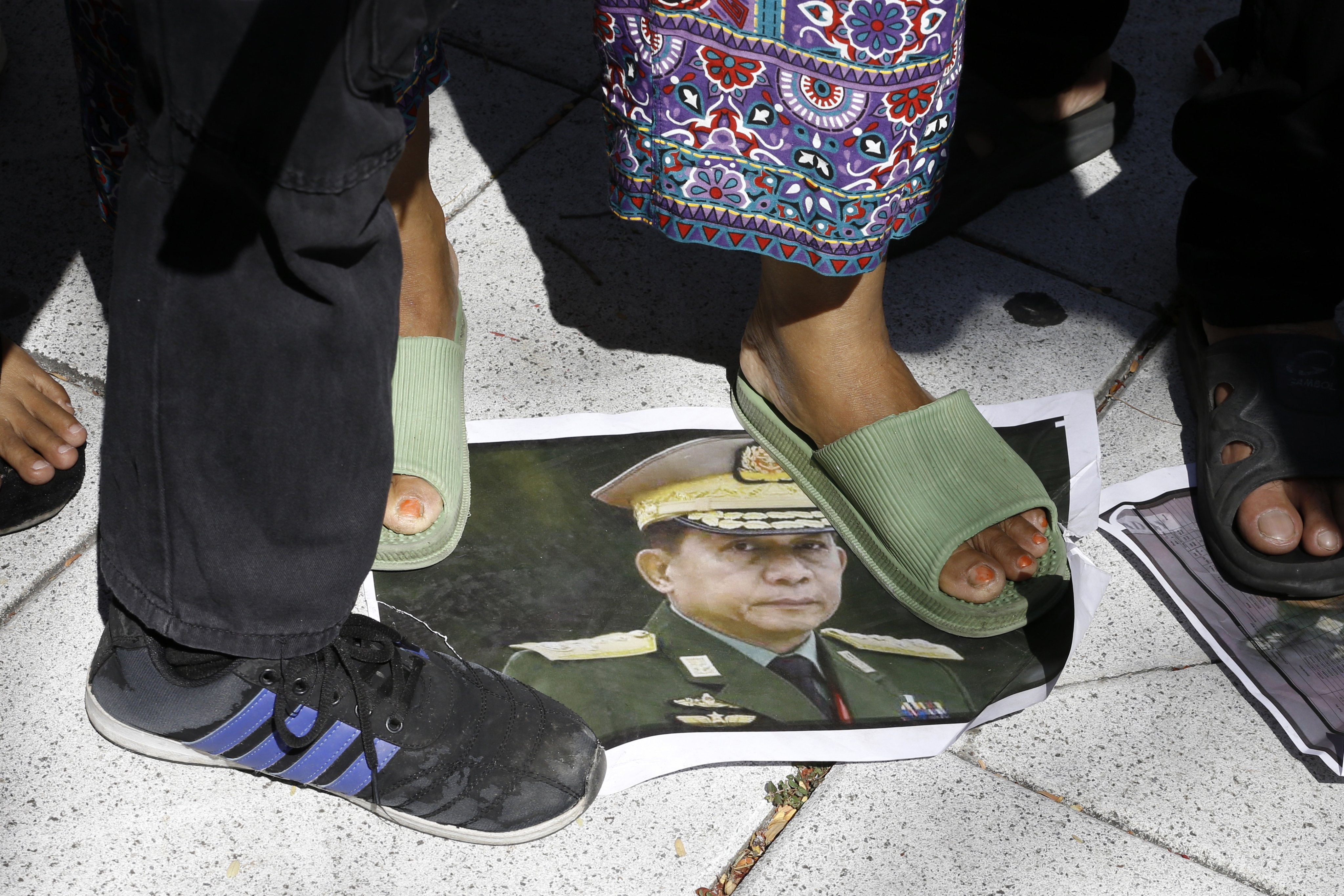 Myanmar migrant workers in Thailand step on a picture of junta chief General Min Aung Hlaing at a rally in Bangkok on Sunday. Photo: EPA-EFE