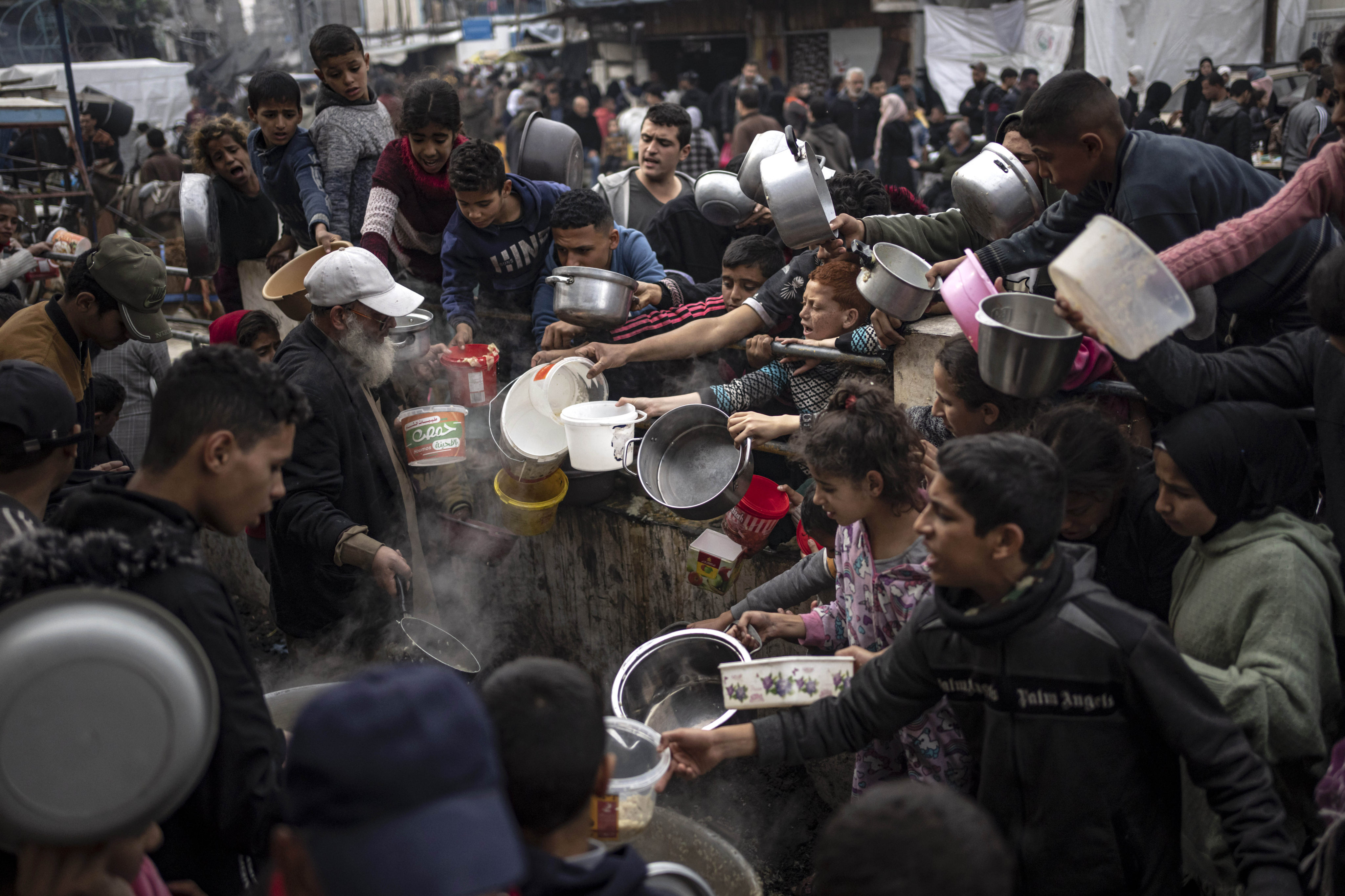 Palestinians converge for a free meal in Rafah, Gaza Strip. International aid agencies say Gaza is suffering from shortages of food, medicine and other basic supplies. Photo: AP
