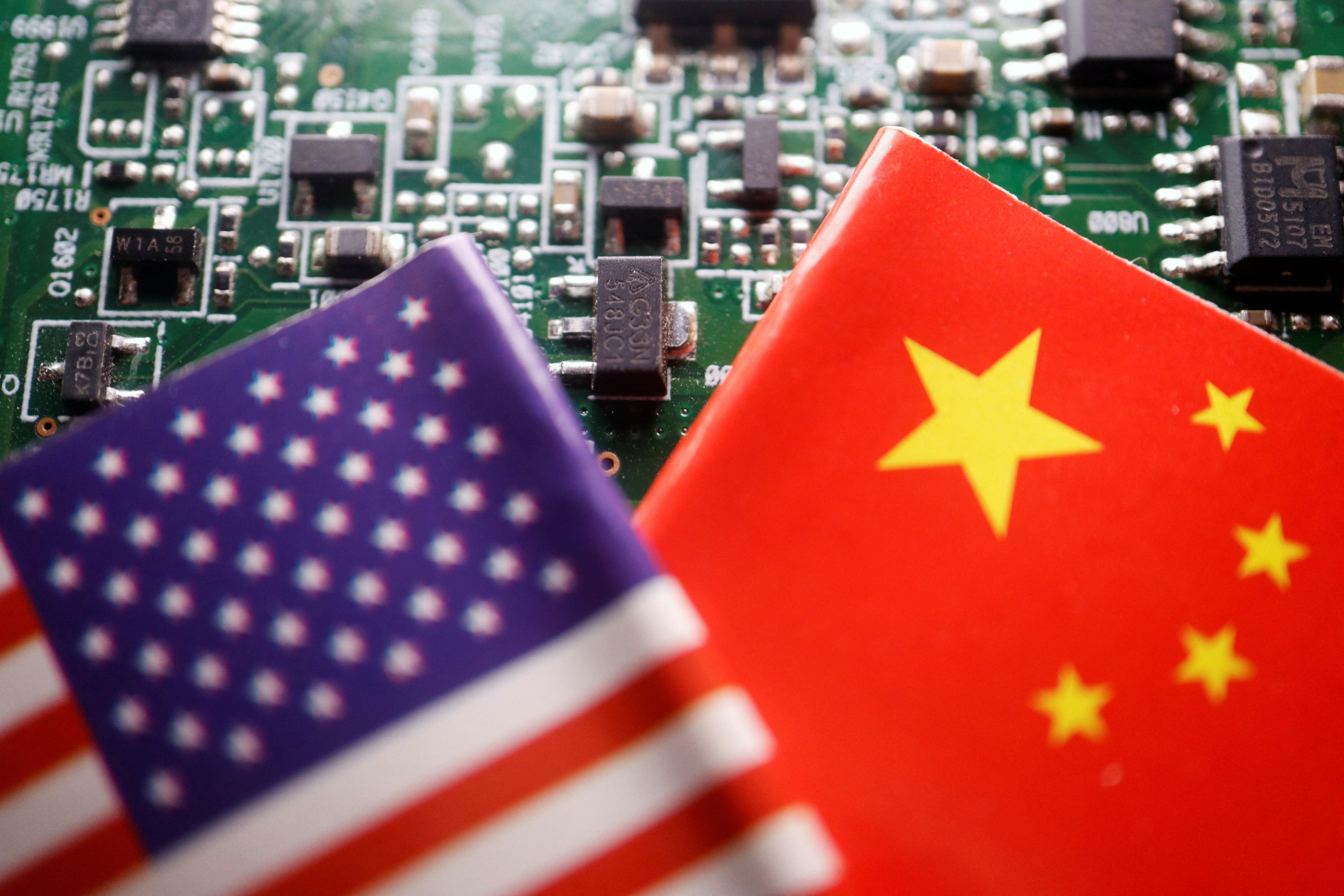 The flags of China and the US displayed on a printed circuit board with semiconductor chips. Photo: Reuters / Florence Lo / Illustration