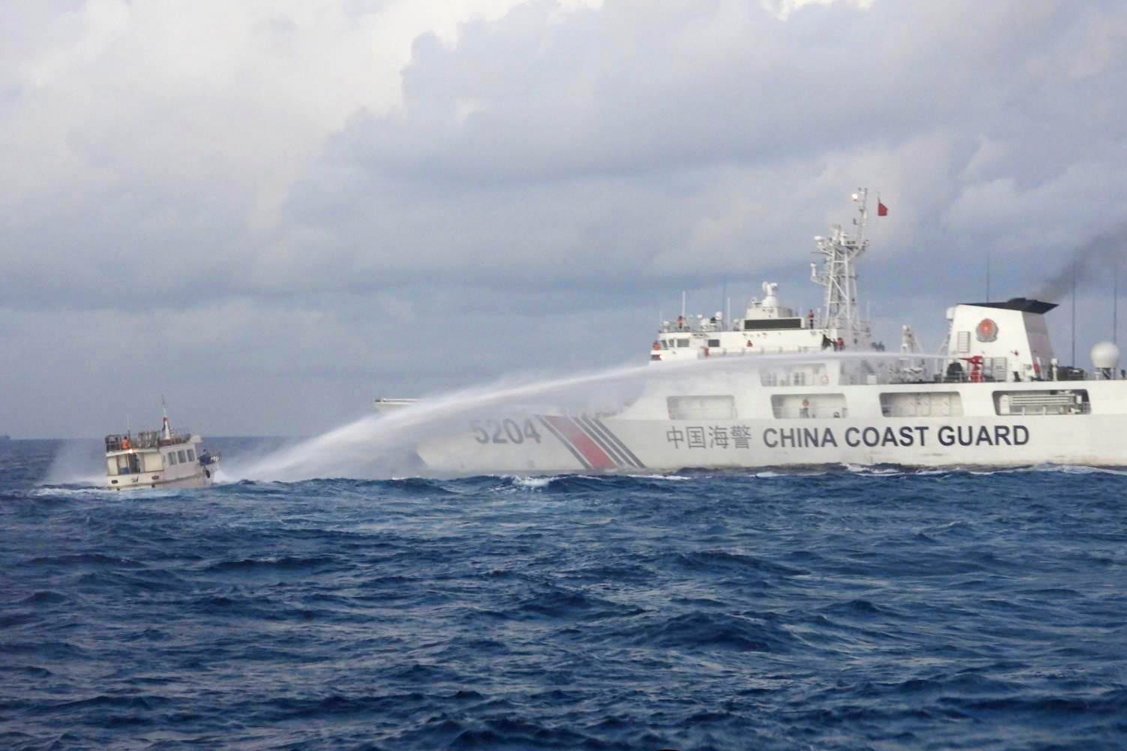 A Chinese Coast Guard ship uses water cannons on a Philippine navy-operated supply boat as it approaches Second Thomas Shoal, locally known as Ayungin Shoal, in the disputed South China Sea on December 10. Photo: Philippine Coast Guard via AP