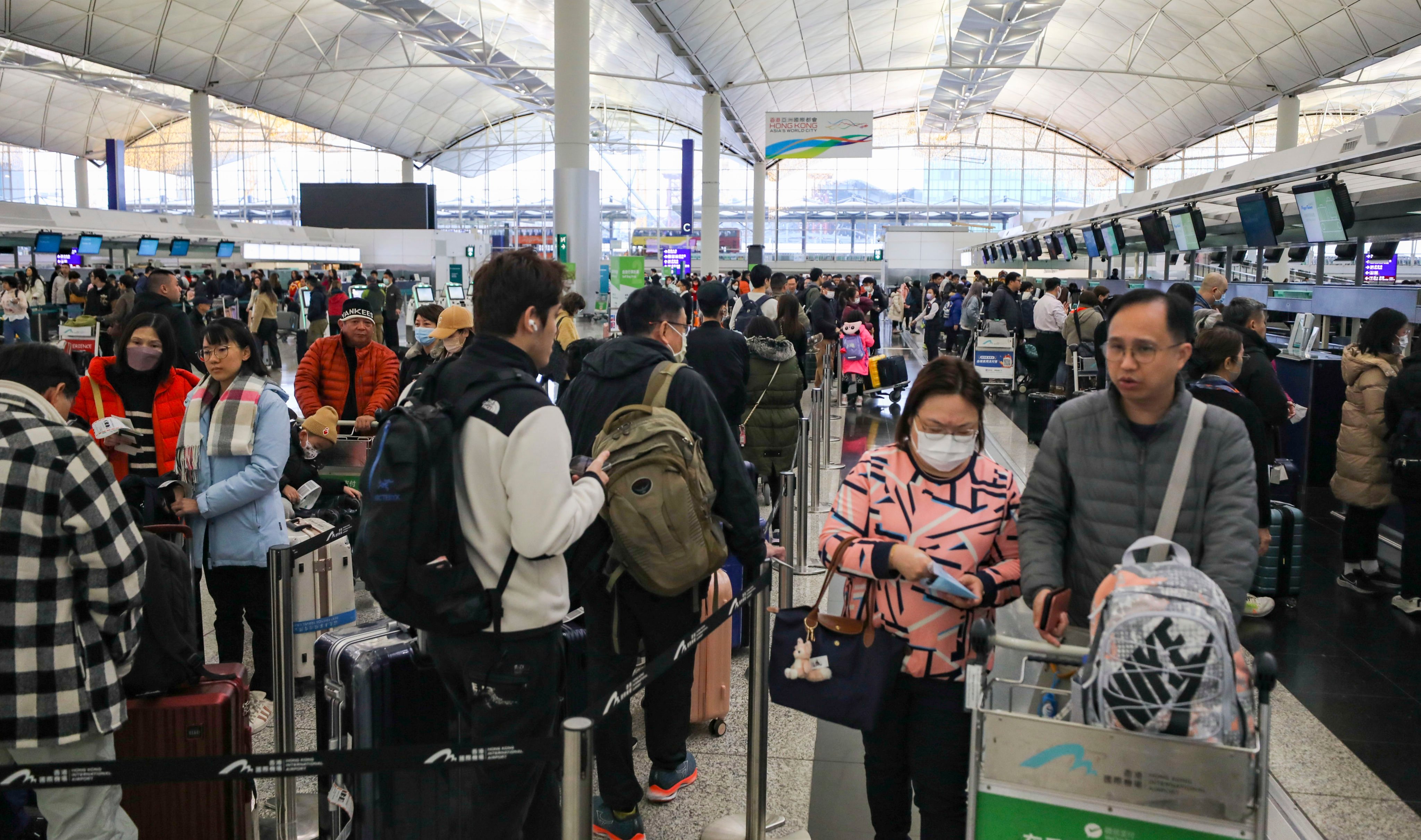 Passengers wait to check in for their flights at a packed Hong Kong airport on Saturday. Photo: Xiaomei Chen
