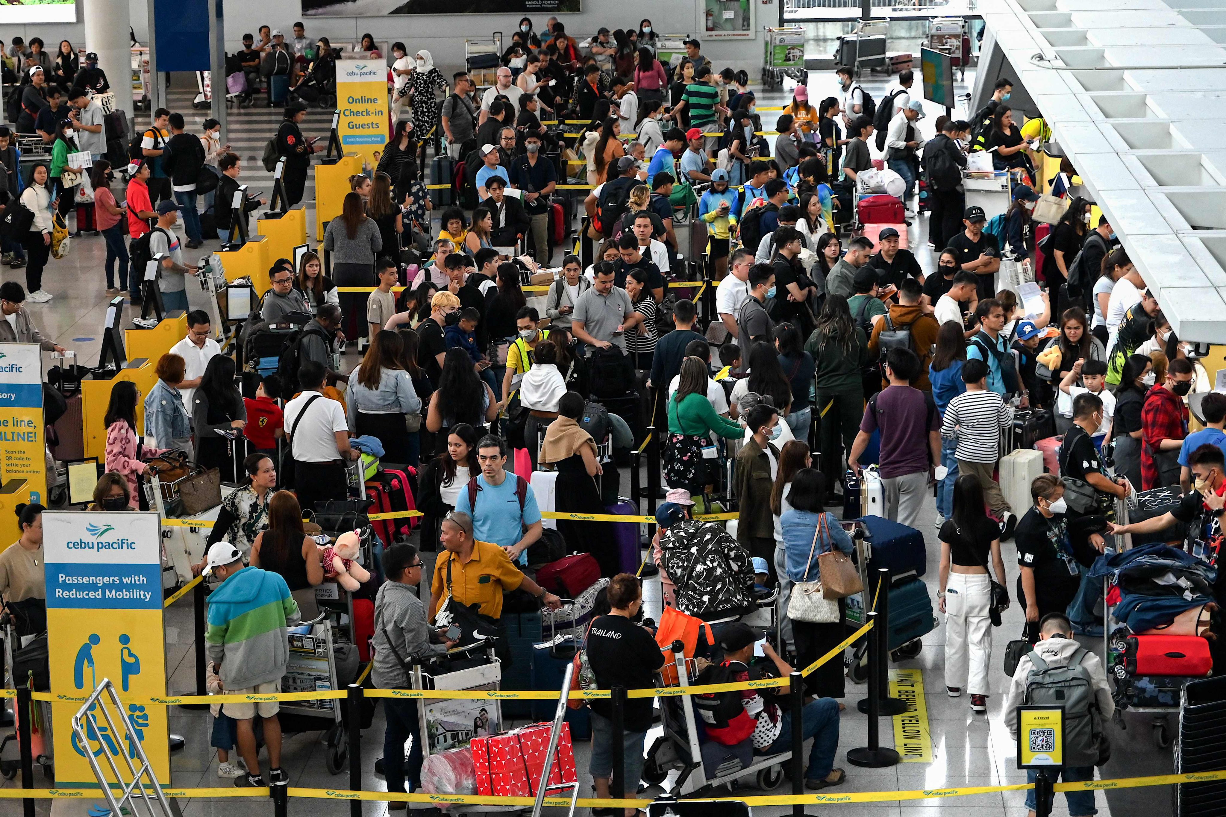 People queue at the check-in counters at Ninoy Aquino International Airport in Pasay, Metro Manila on December 22. Industry data showed a decline in the number of Asia-Pacific airlines among the top 20 most on-time and least cancelled airlines worldwide. Photo: AFP