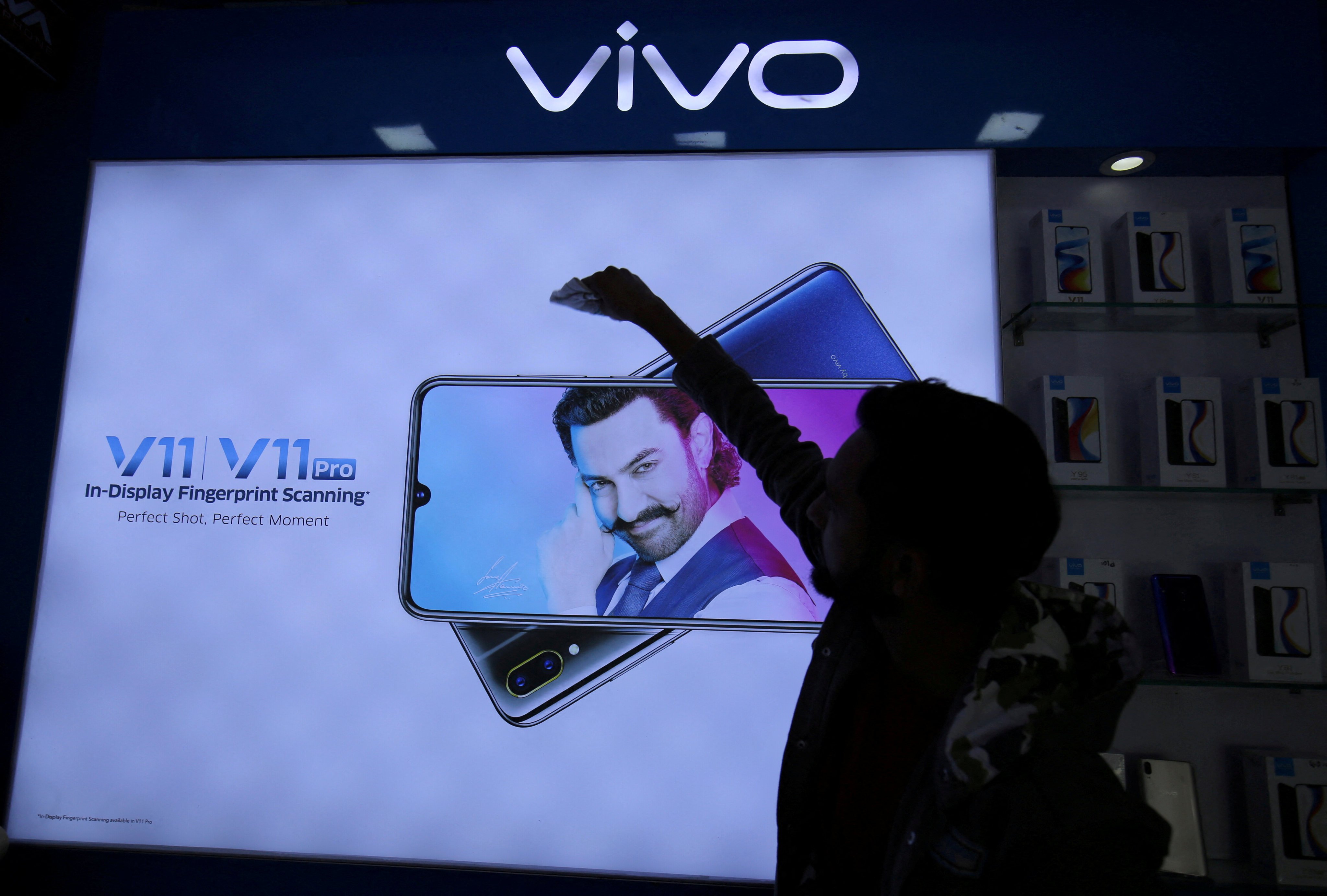 A man cleans a screen advertising a Vivo smartphone inside a shop in Ahmedabad, India in December 2018. Photo: Reuters