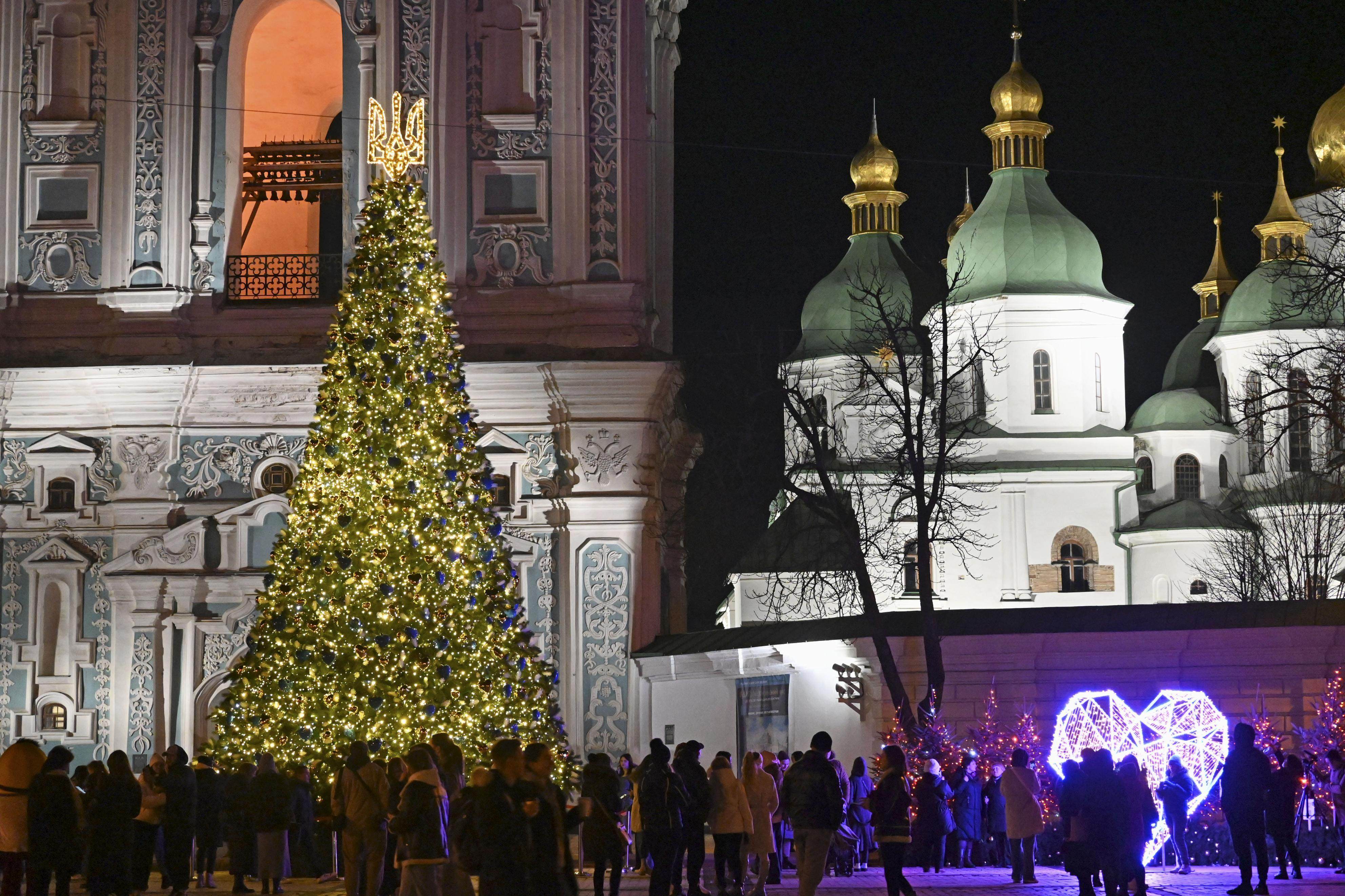 People gather around a giant Christmas tree in front of Saint Sophia Cathedral in Kyiv on last Wednesday. Photo: Kyodo