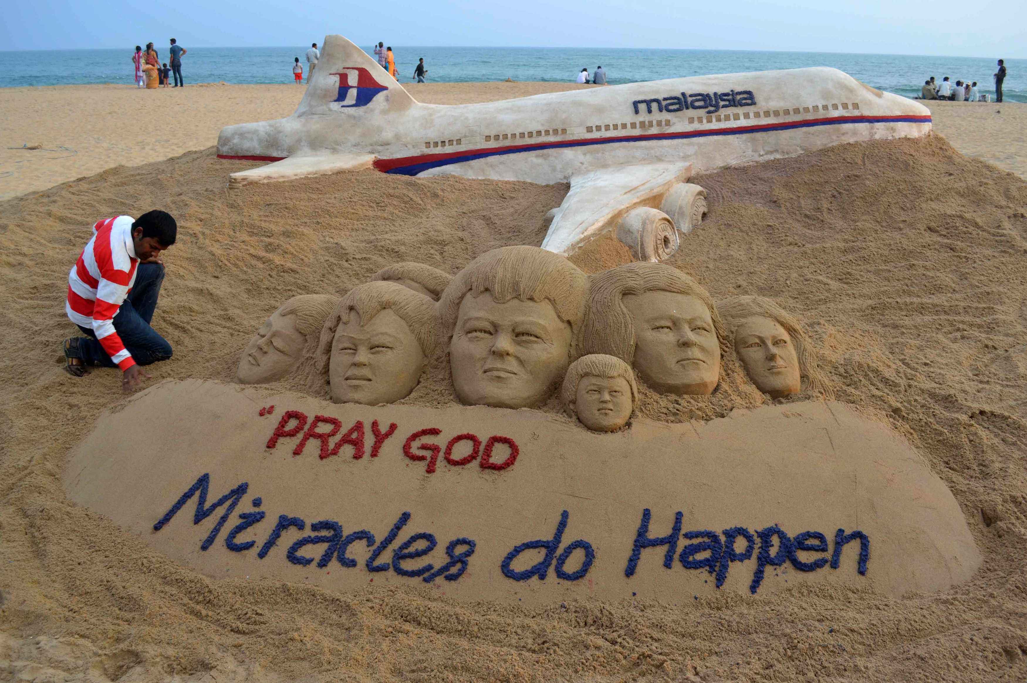 Indian sand artist Sudarshan Patnaik applies the final touches to a sand art sculpture wishing for the well being of the passengers of Malaysian Airlines flight MH370. Photo: Reuters/File