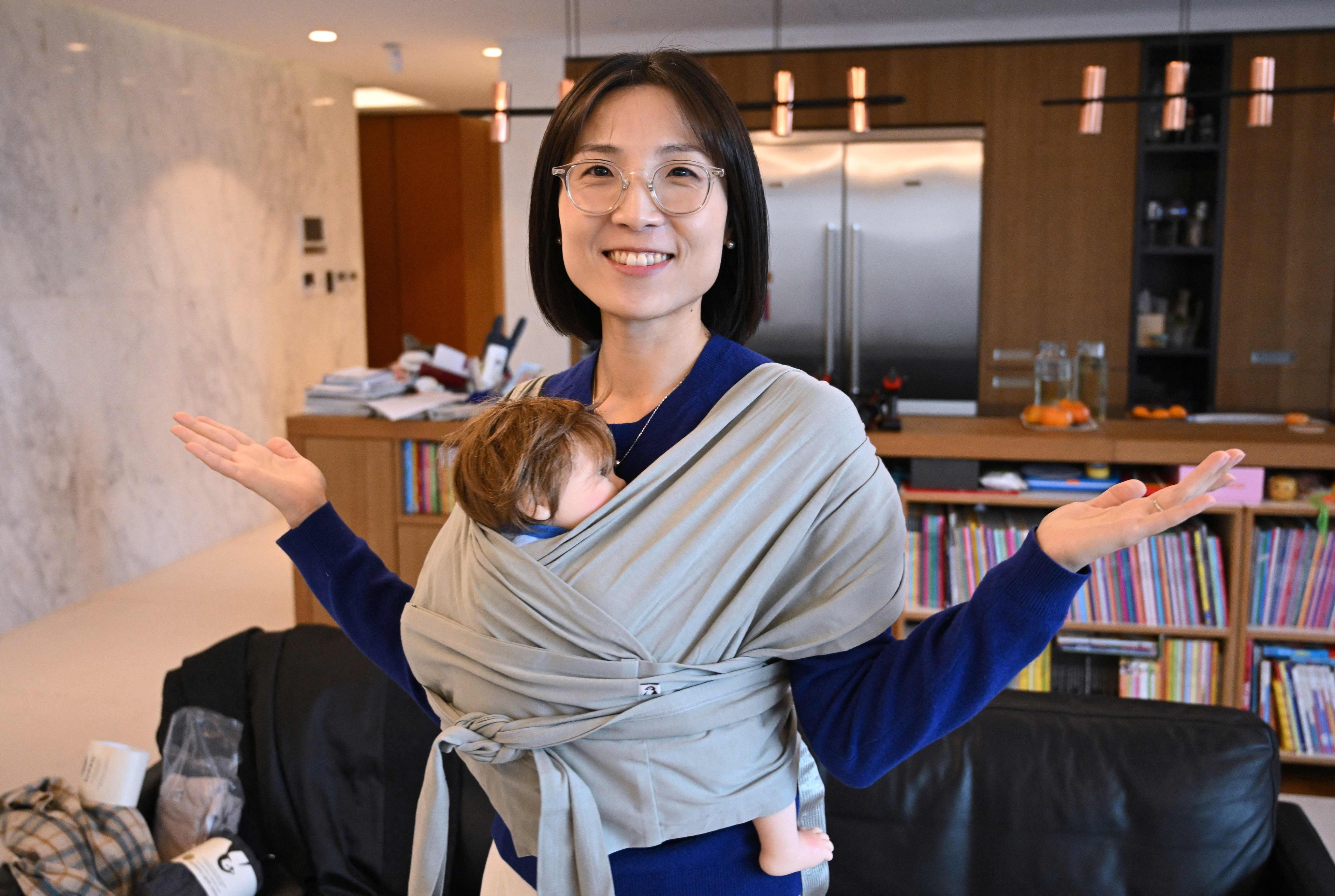 Konny CEO Erin Lim demonstrating a baby carrier at her home in Seoul. Photo: AFP